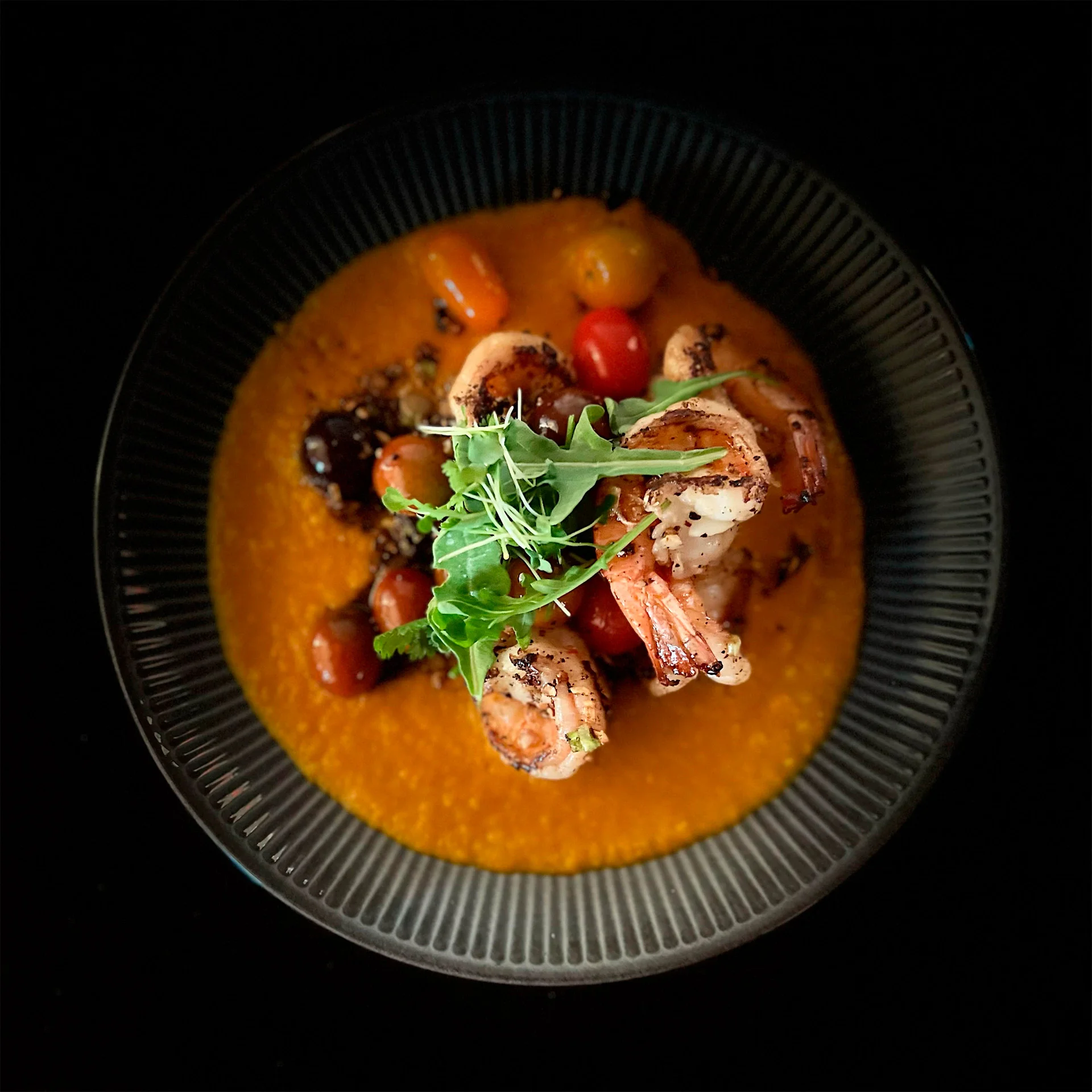 Grilled shrimp over a vibrant tomato sauce in a gourmet presentation