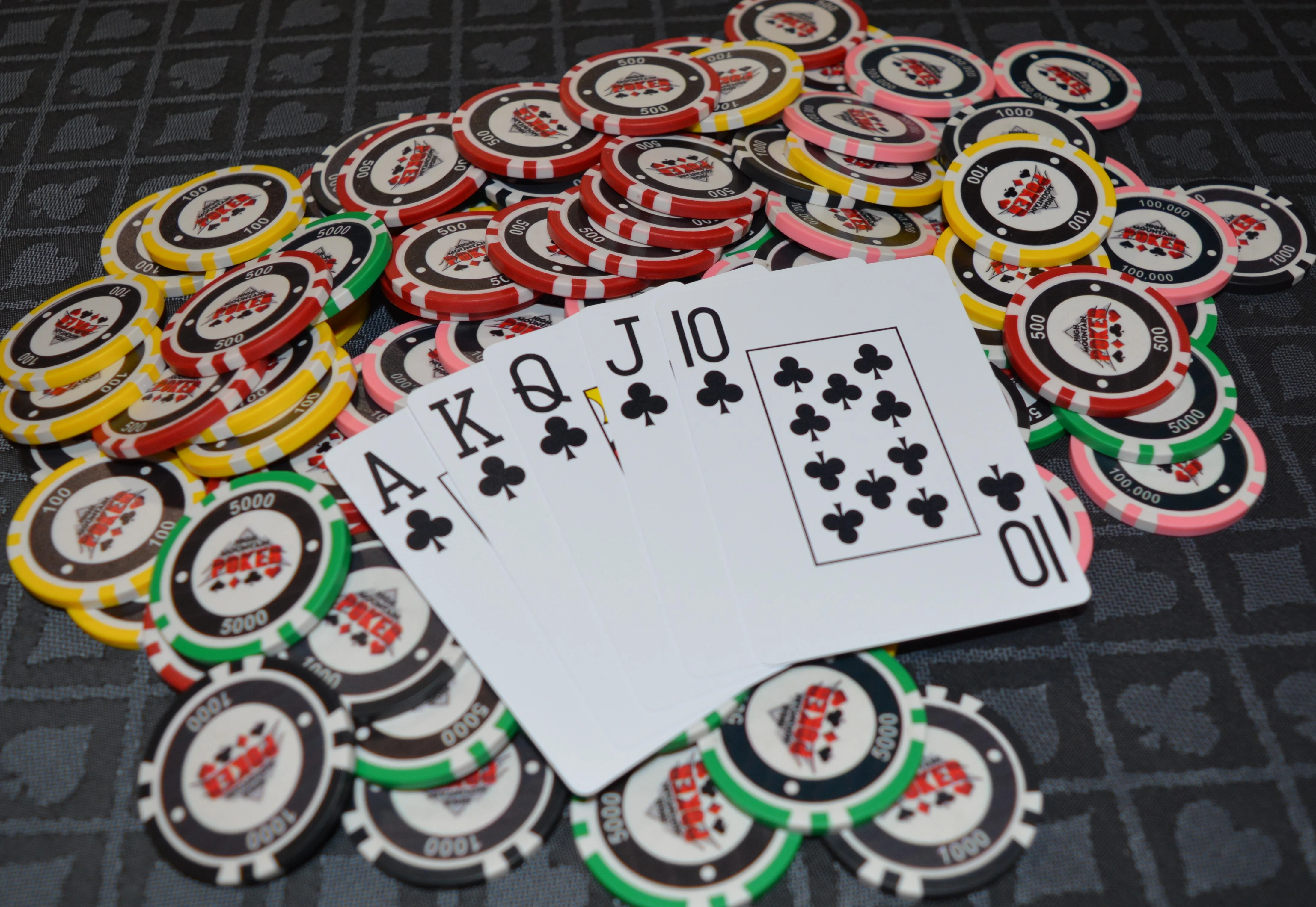 Poker hand with royal flush and colorful chips