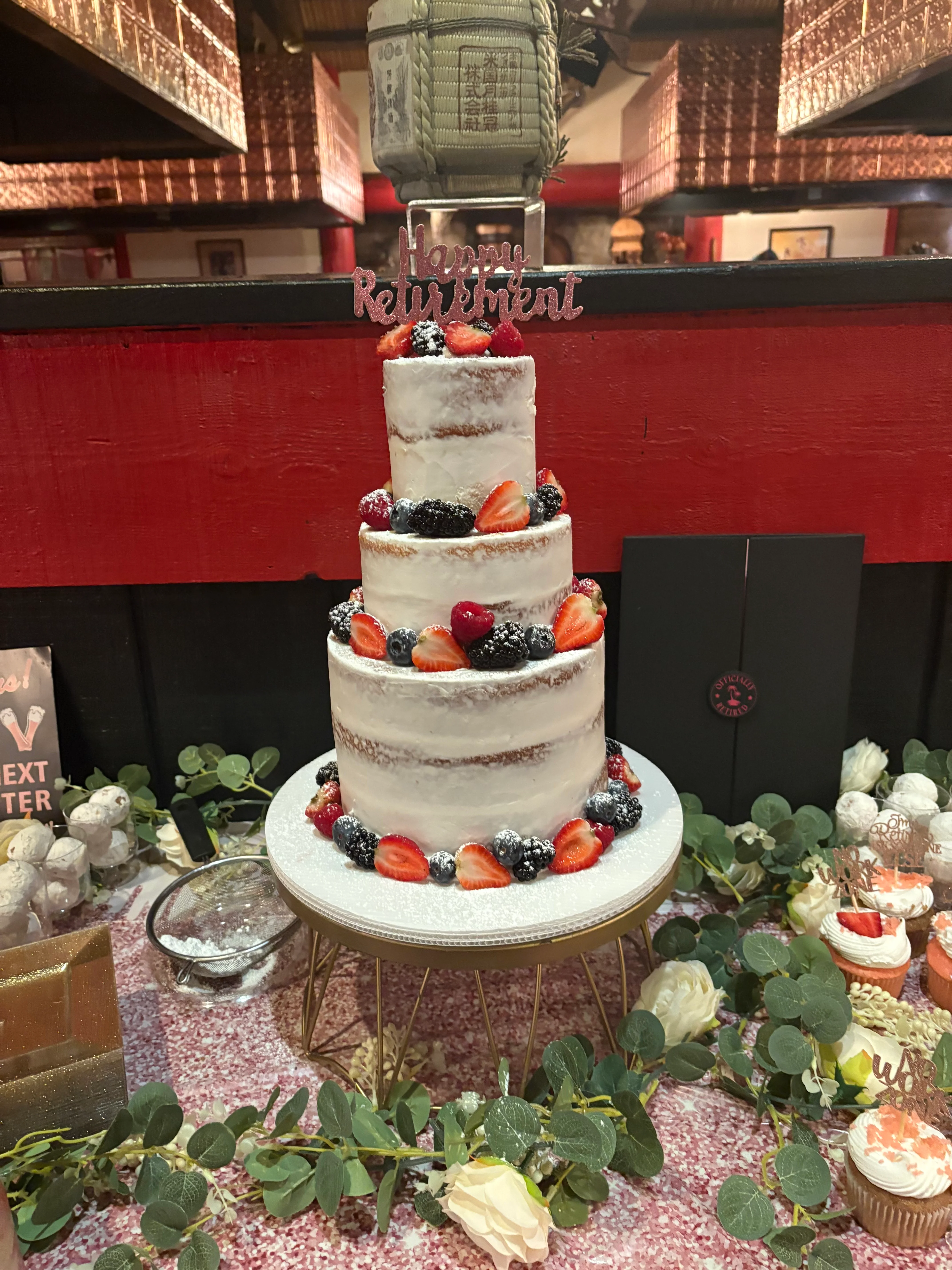 Elegant retirement cake with fresh berries and decorative topper