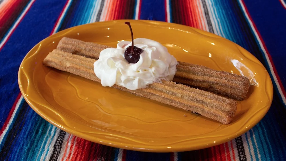 Aztec on Broadway Mexican Restaurant Portland - Churros with whipped cream and cherry on yellow plate
