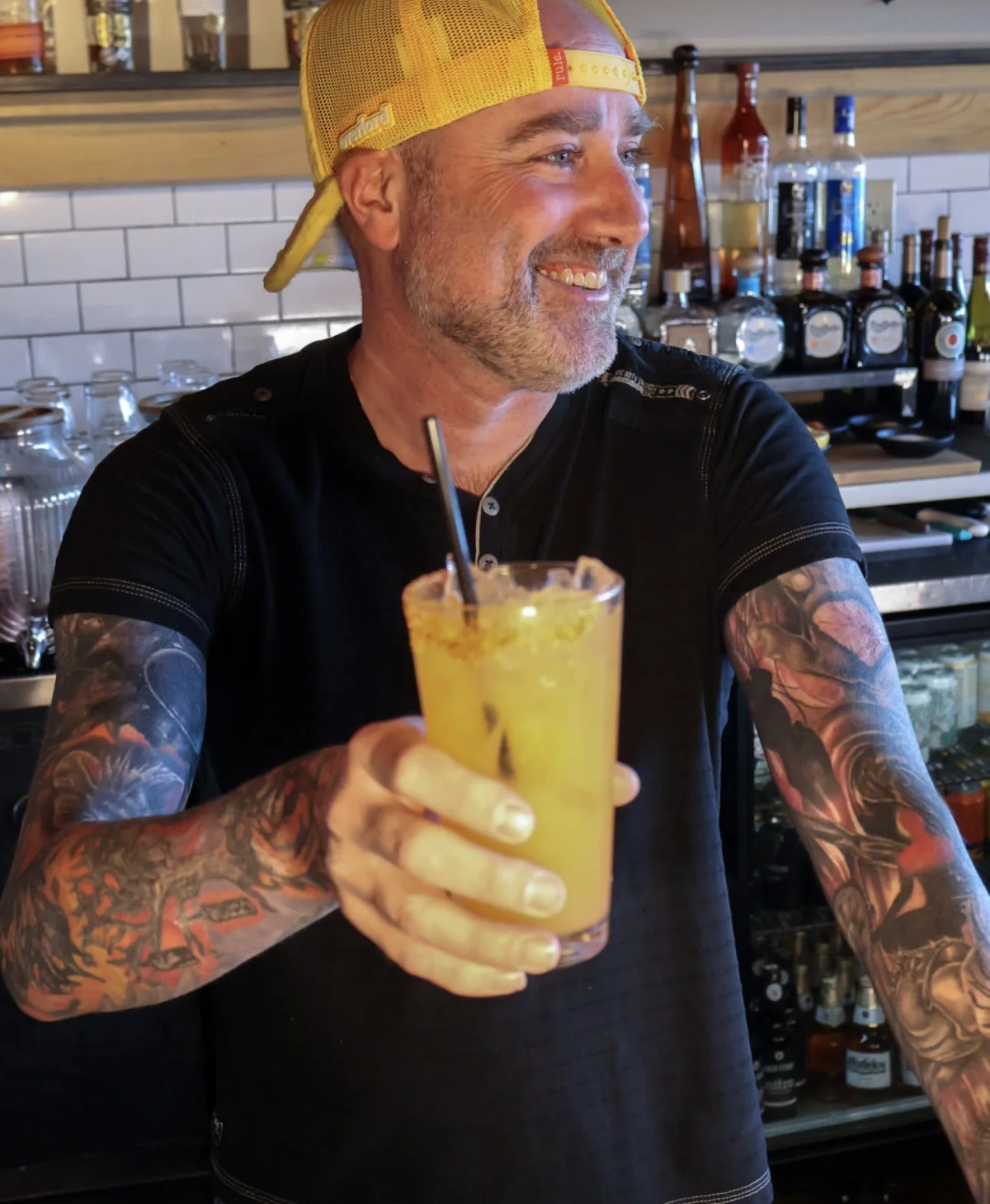 Bartender serving a vibrant cocktail at a stylish bar