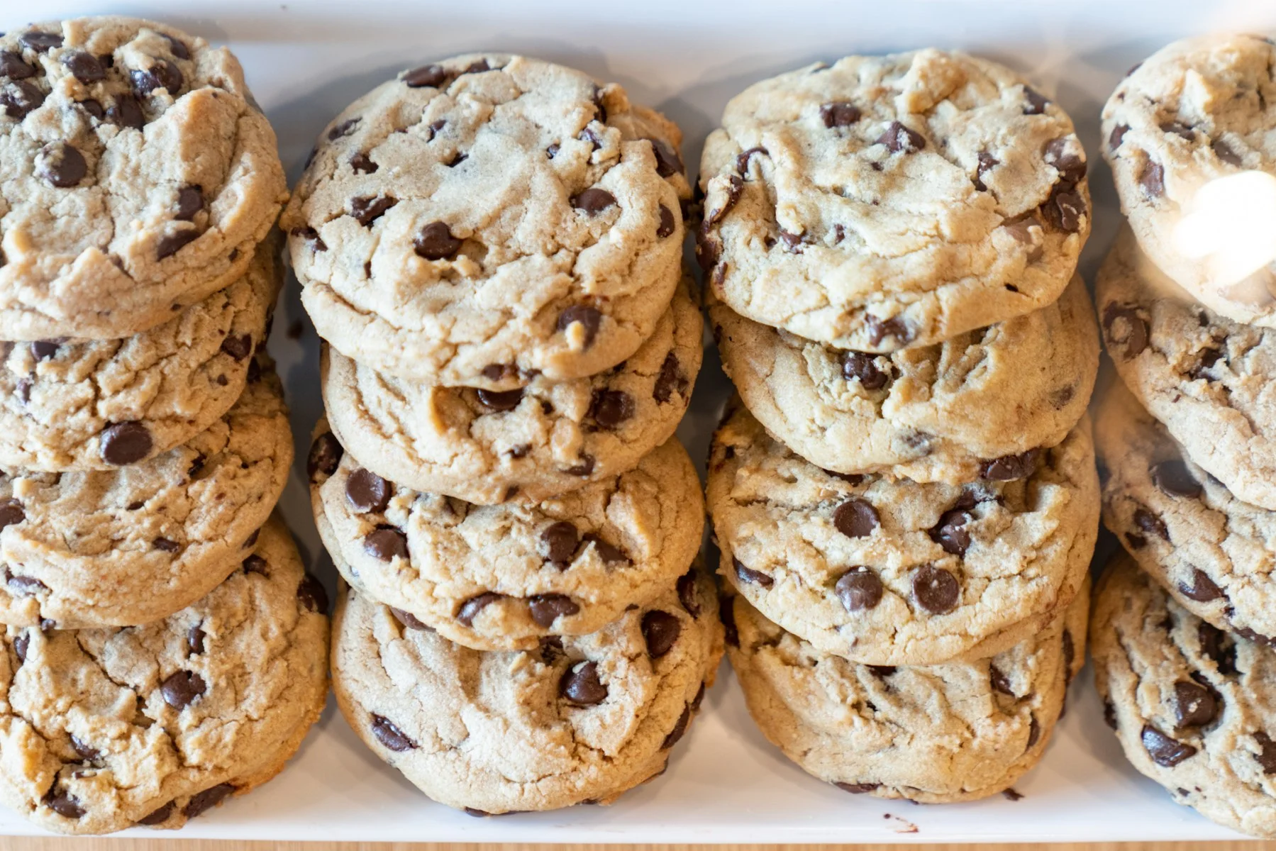 Freshly baked chocolate chip cookies stacked on a platter