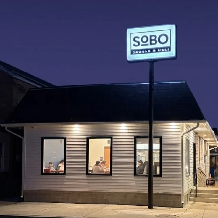 Exterior view of SOBO restaurant at night with illuminated sign