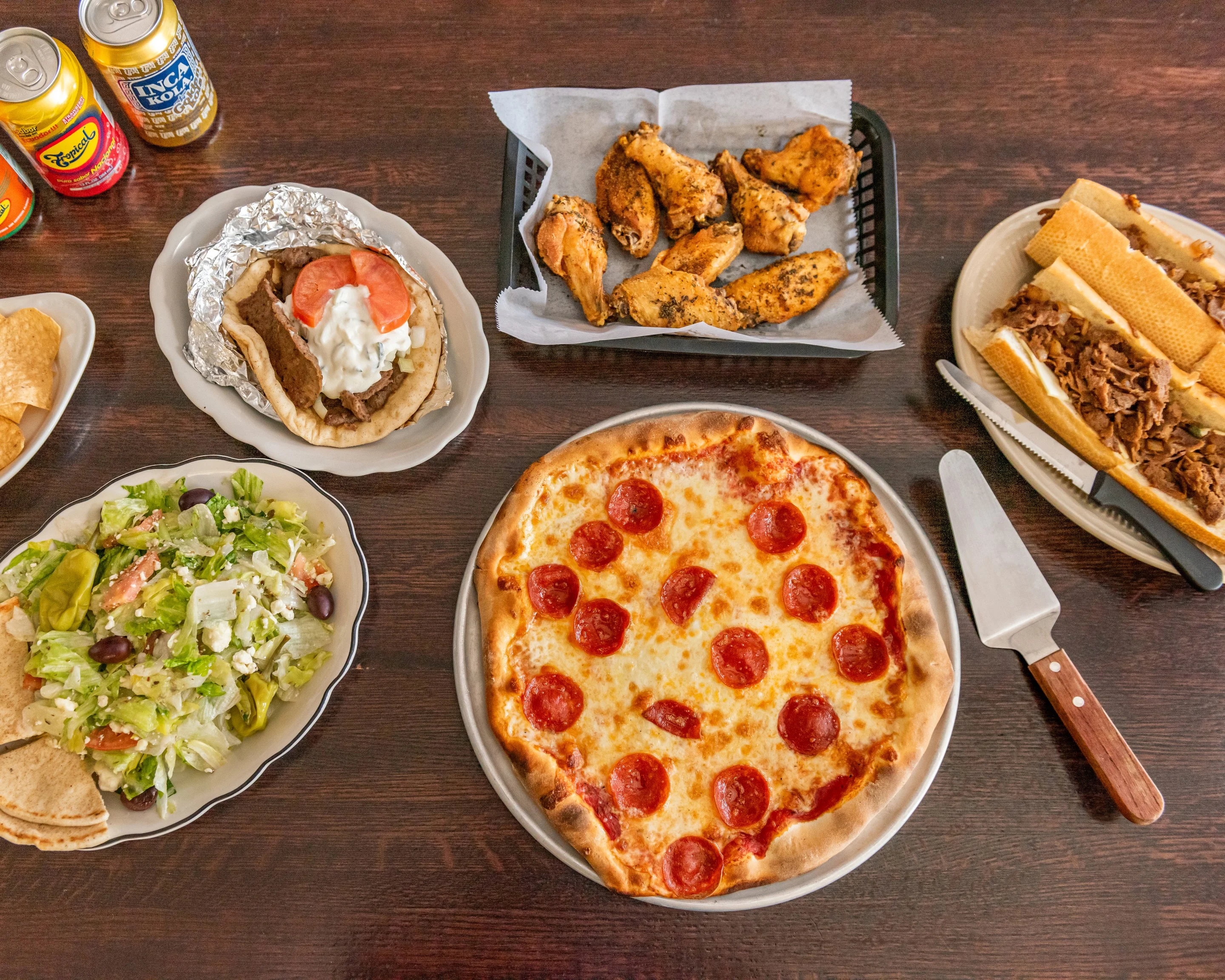 Delicious pepperoni pizza with sides of wings and salad