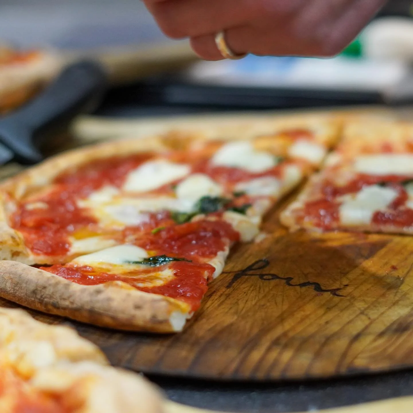 Margherita pizza on a wooden board with fresh mozzarella and basil
