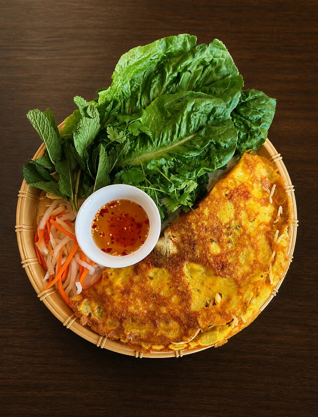 Vietnamese bánh xèo served with fresh herbs and dipping sauce