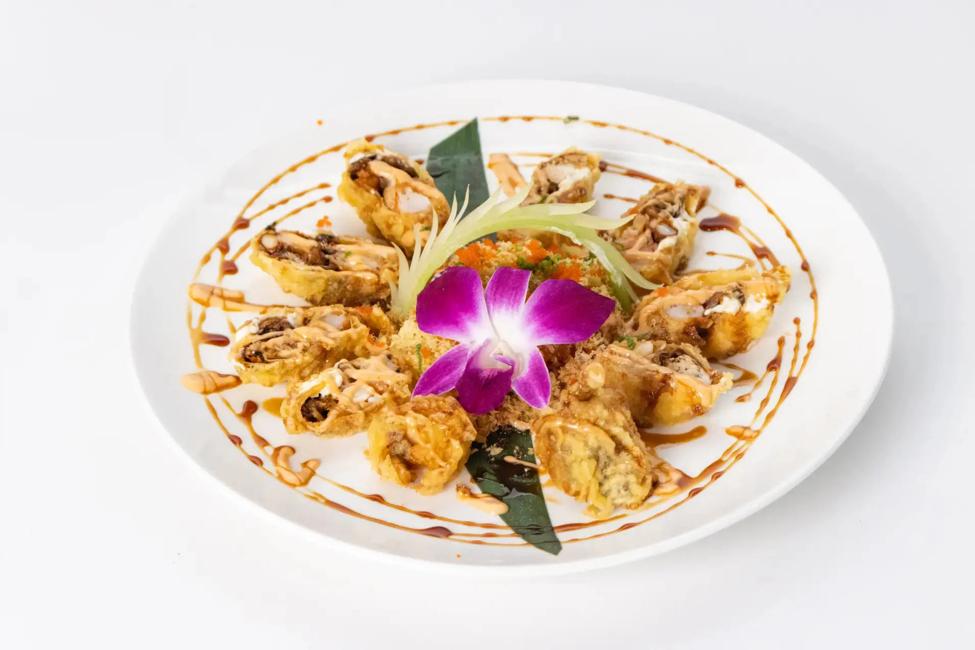 Crispy Japanese sushi rolls garnished with a purple orchid