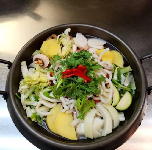 Sichuan hot pot with fresh vegetables and herbs