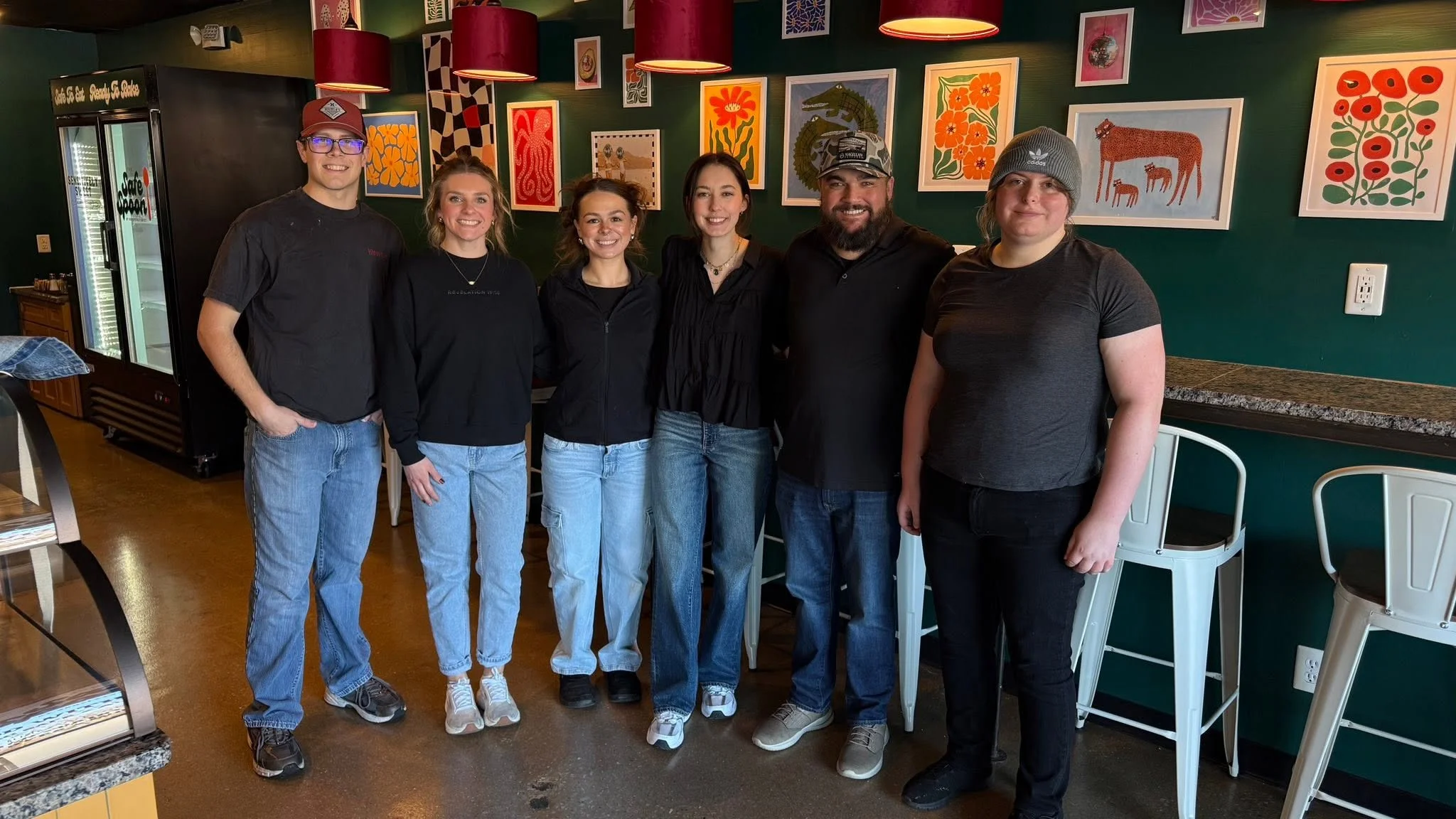 Friendly restaurant staff posing together in a cozy dining area