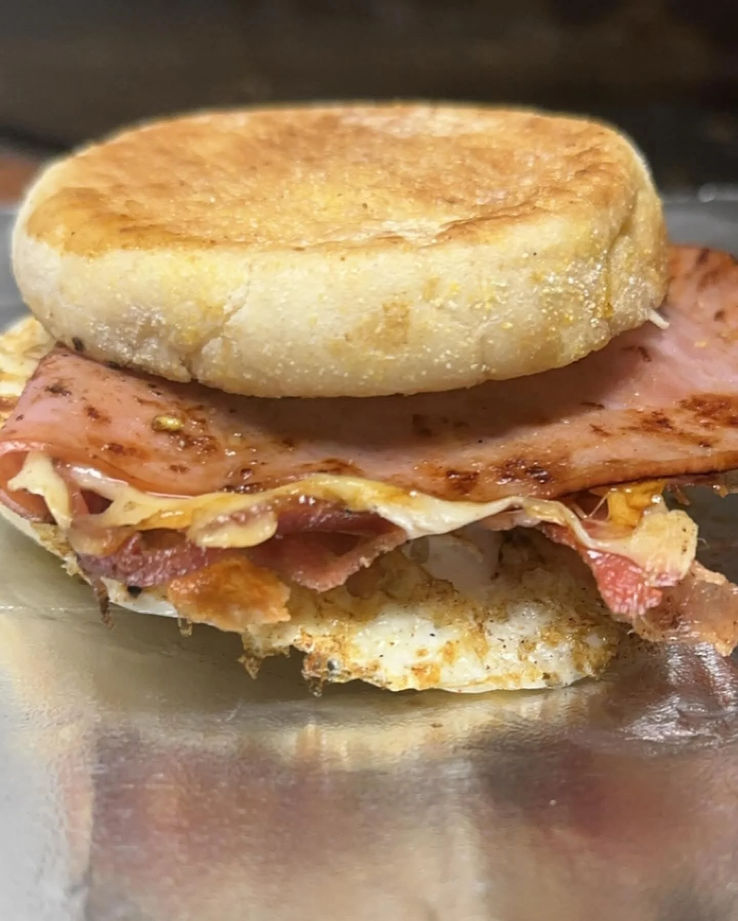 Breakfast sandwich with ham and egg on an English muffin