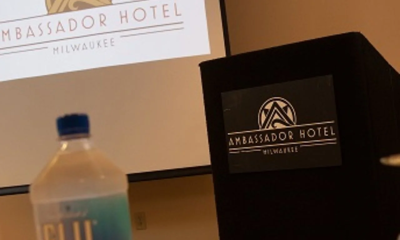 Ambassador Hotel conference setup with branding and water bottle