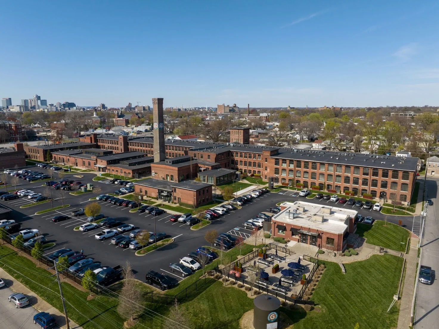 Aerial view of a historic brick building complex with parking and green spaces