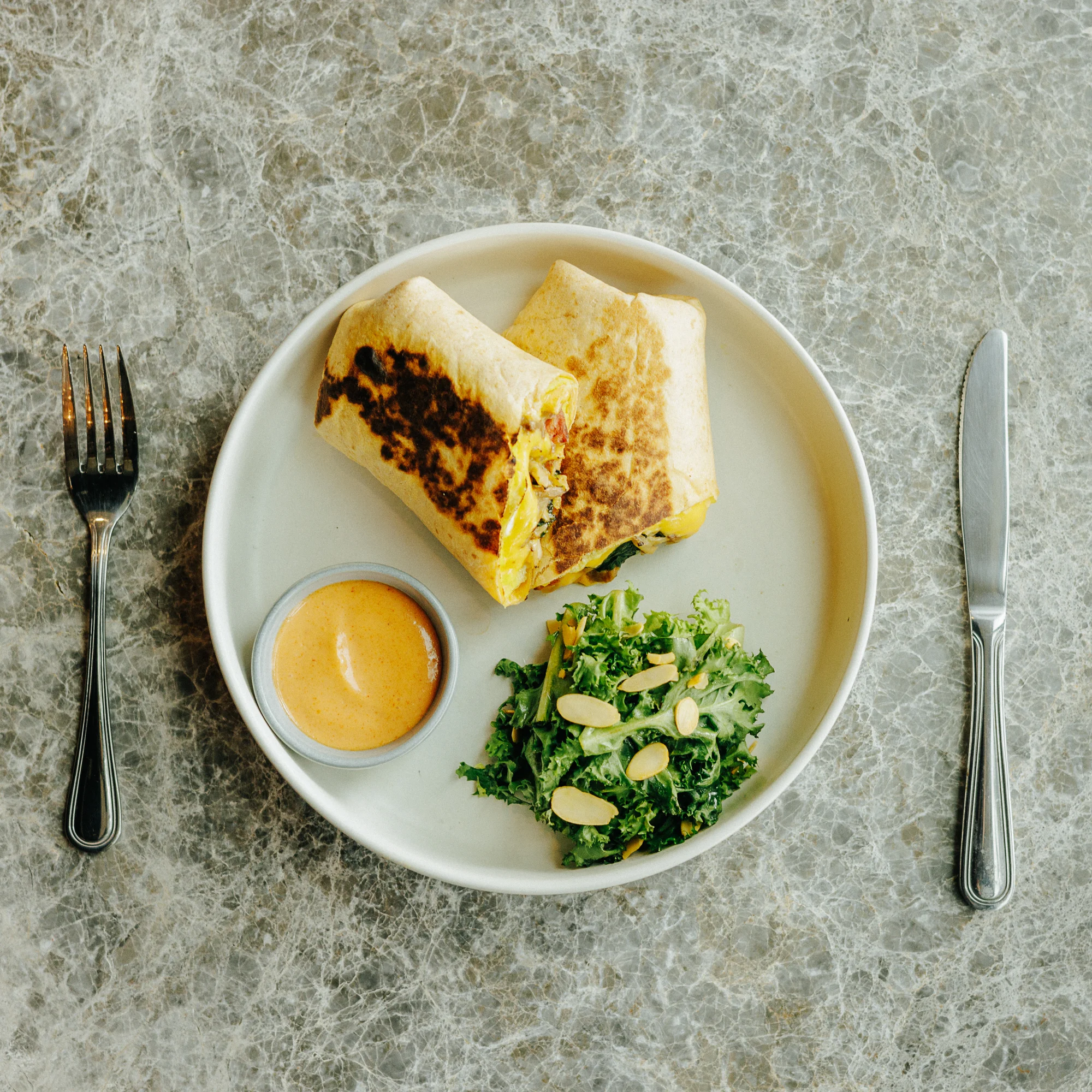 Breakfast burrito with fresh greens and dipping sauce