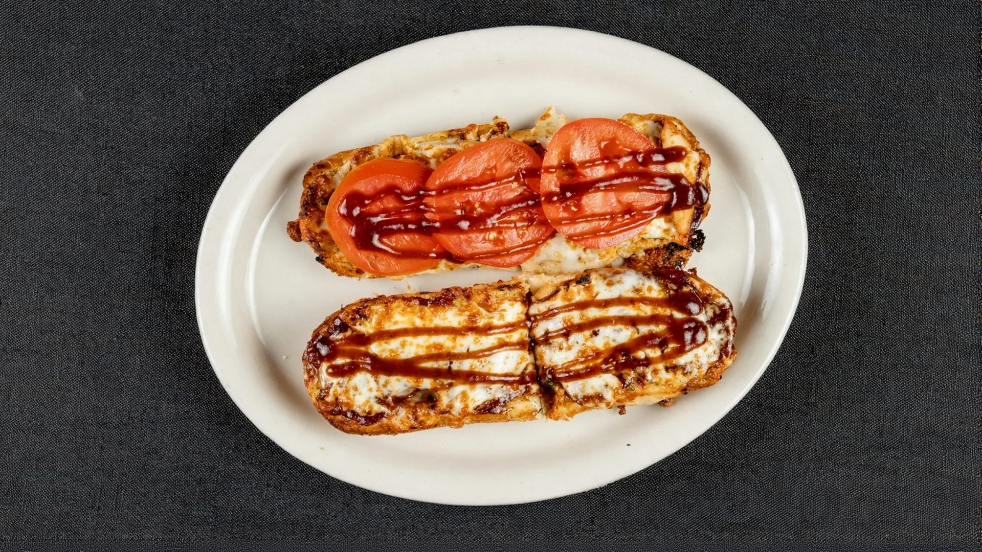 BBQ chicken sandwich with toppings on a wooden table