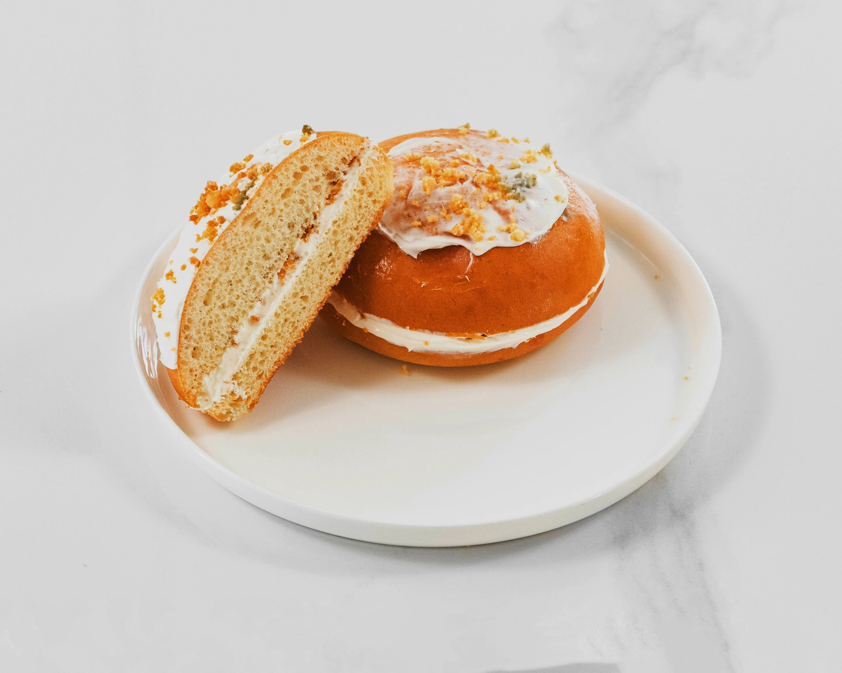 Cream-filled donut with frosting and crumbs