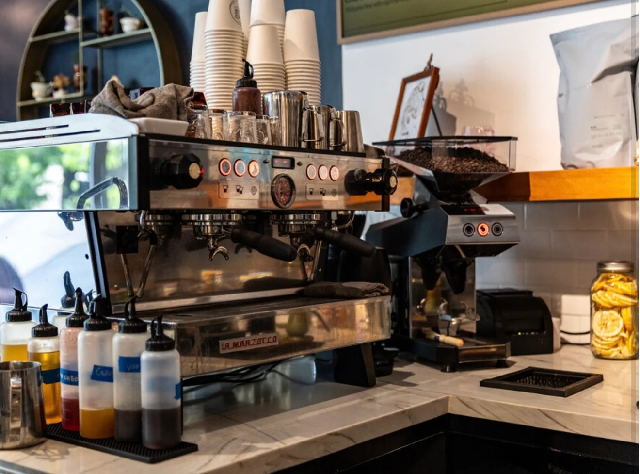 Coffee machine and supplies in a modern café setting.