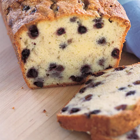Classic blueberry loaf cake sliced on a wooden board