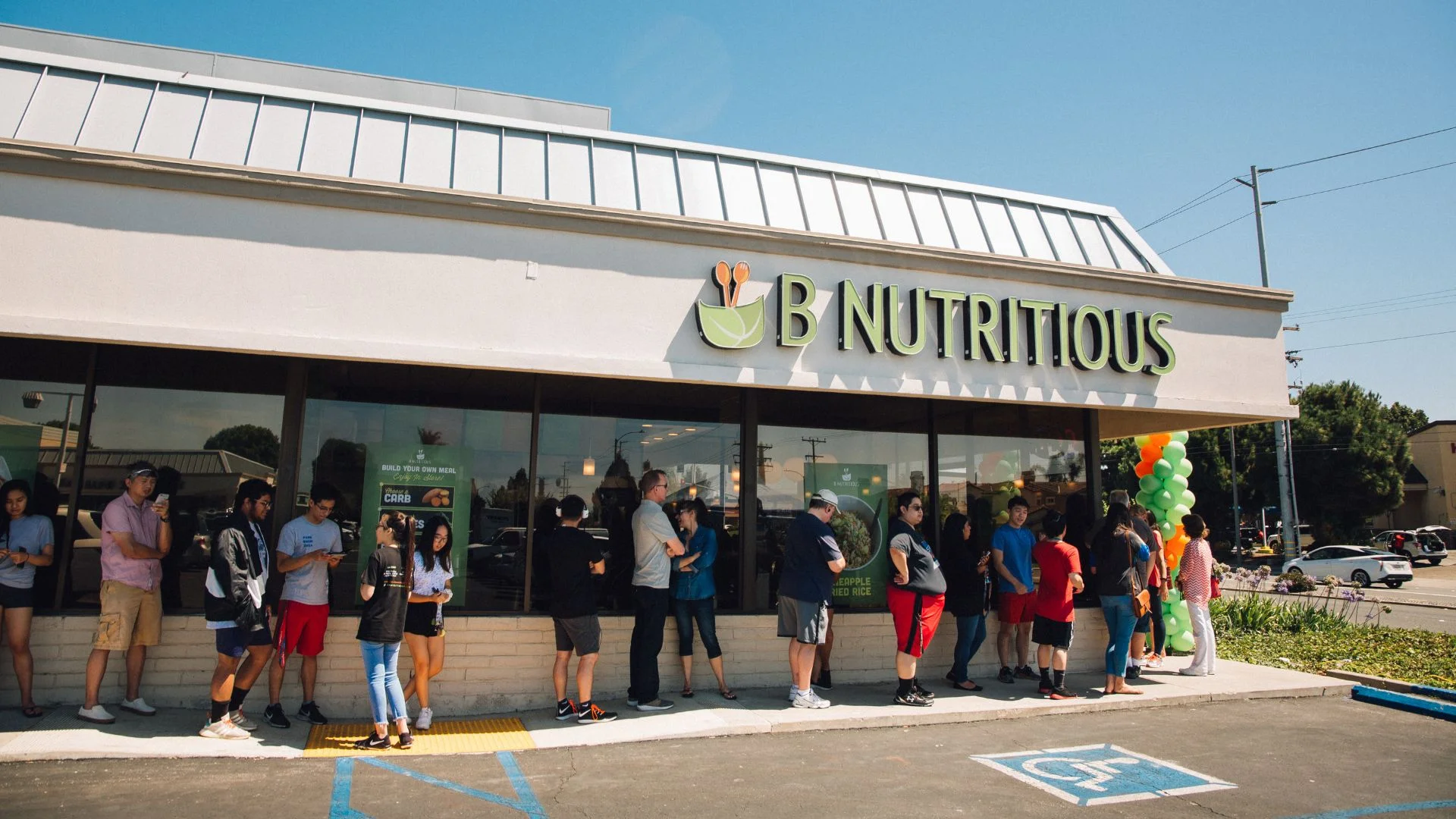 Exterior of B Nutritious restaurant with a line of customers