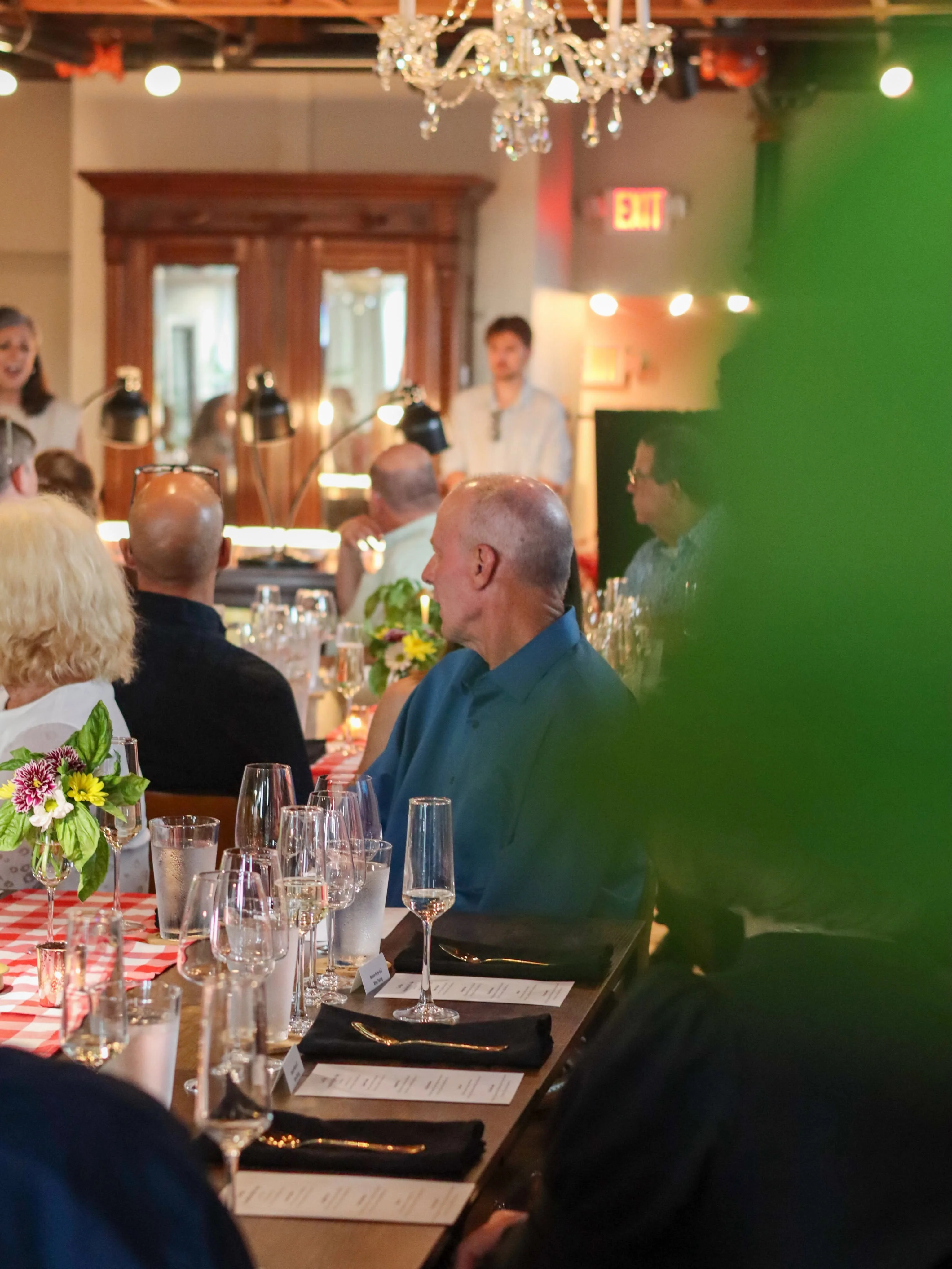 Elegant restaurant dining room with chandelier and guests at a beautifully set table