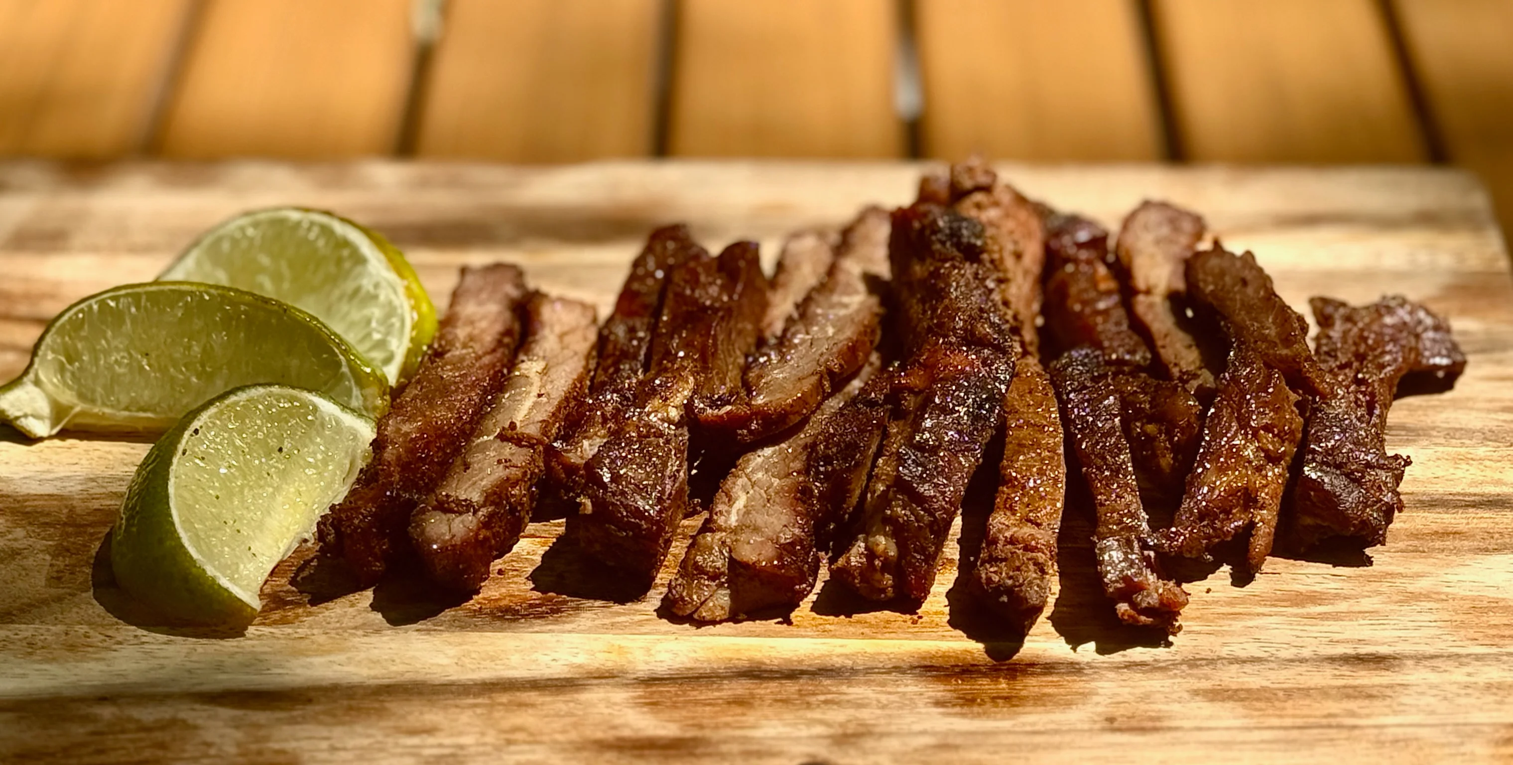 Grilled Mexican carne asada with lime wedges