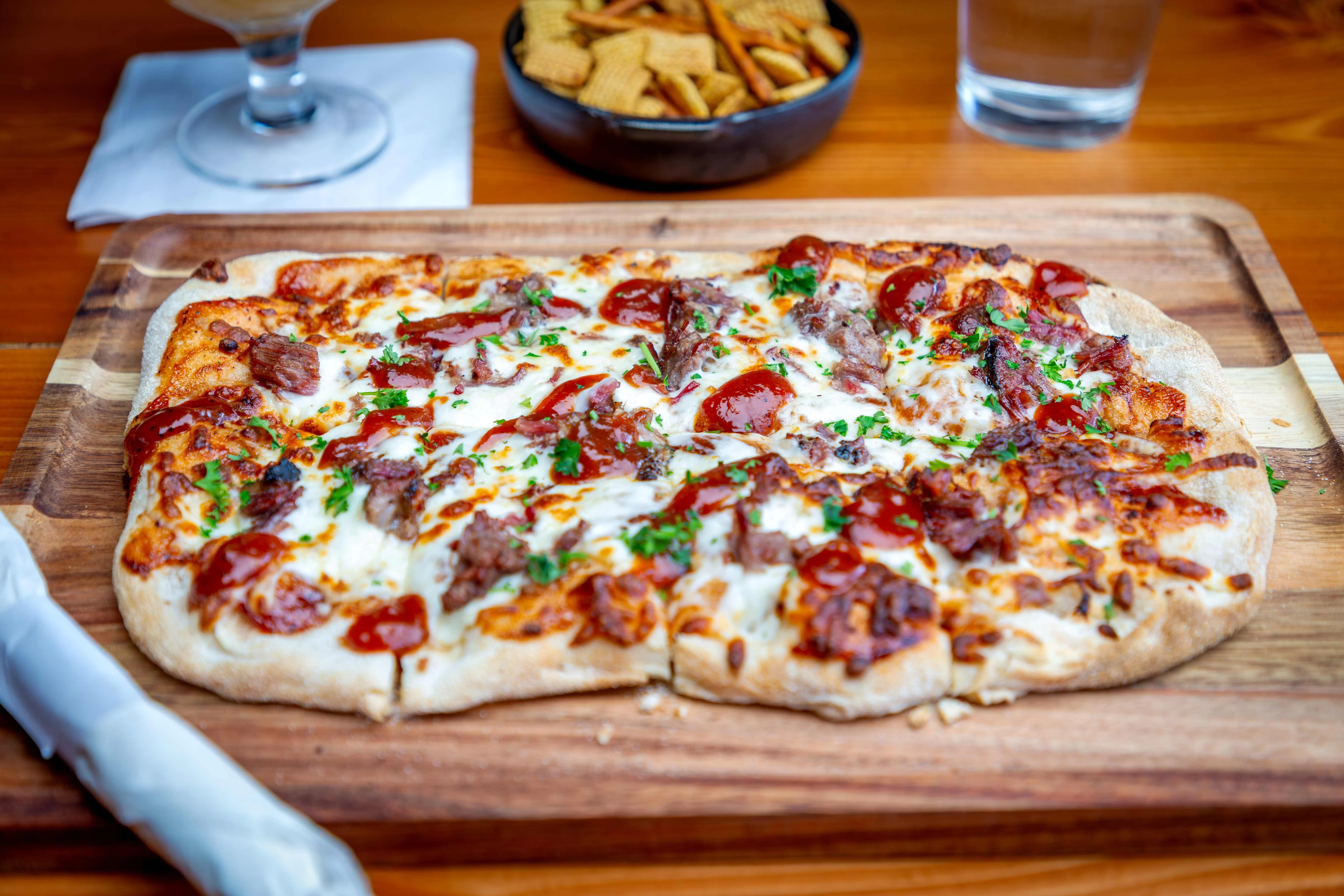 BBQ beef flatbread pizza on a wooden board