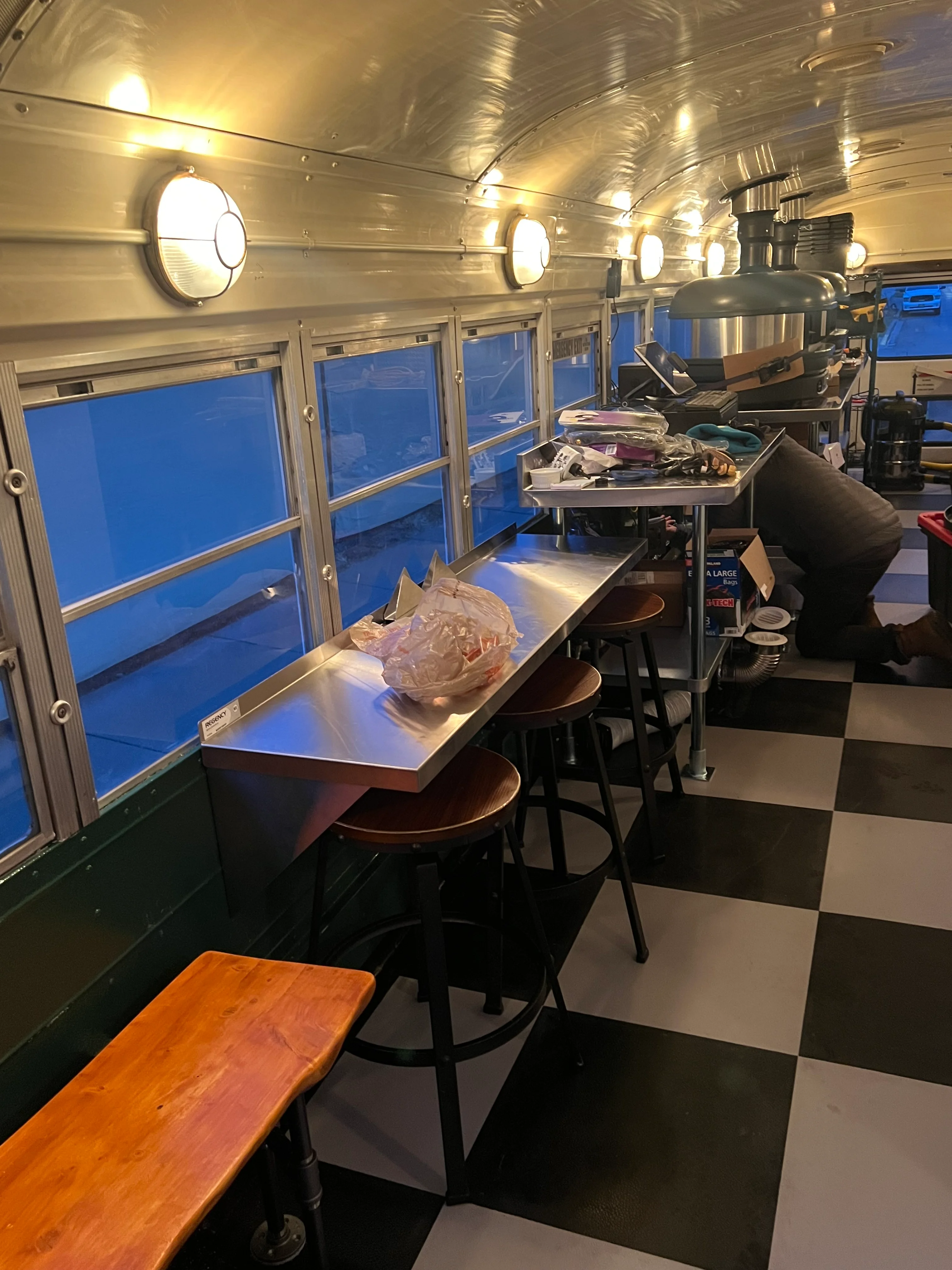Interior of a food truck with seating and kitchen setup