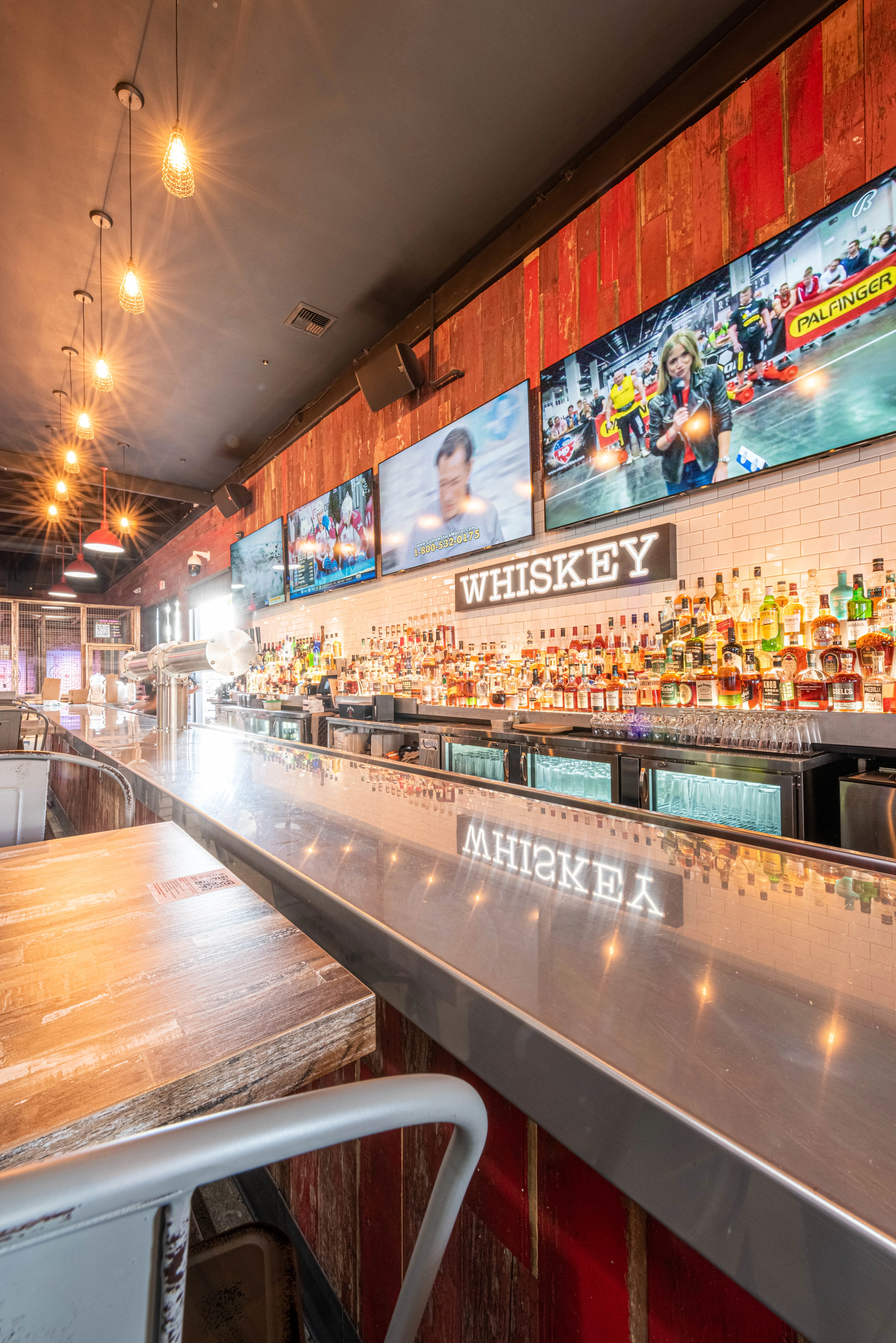 Image of a bar with a lot of whiskey bottles displayed
