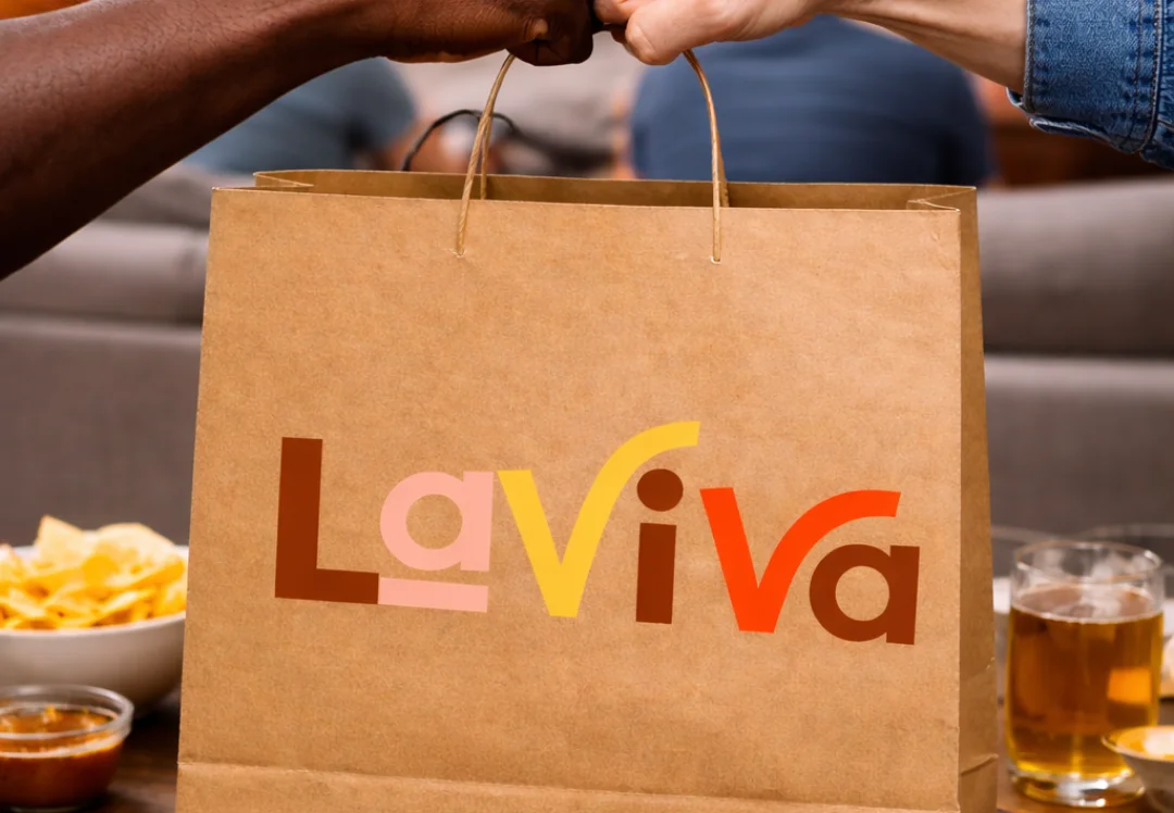 Celebratory fist bump over takeout bag from La Viva restaurant