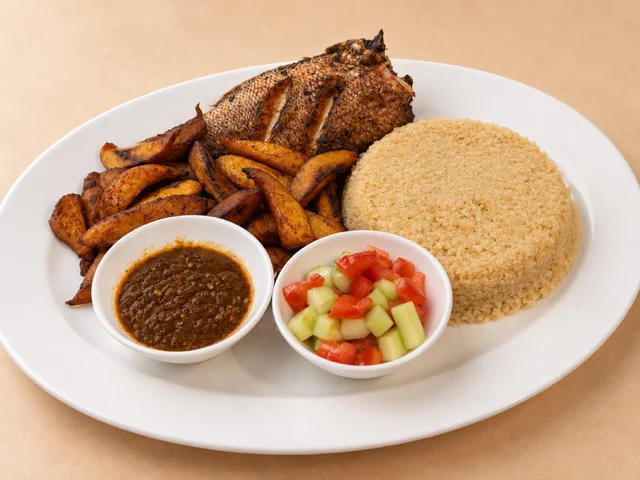 A hearty plate featuring grilled fish, seasoned potato wedges, a mound of couscous, and sides of sauce and salad served in bowls.