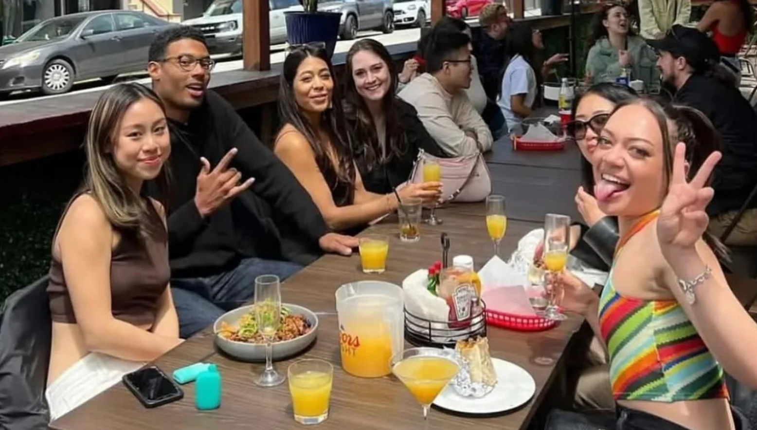 Group of friends enjoying brunch at a lively outdoor restaurant