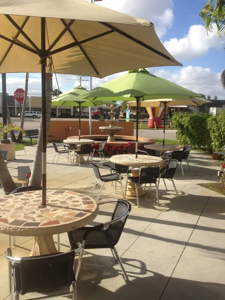 Outdoor dining area with shaded tables and umbrellas