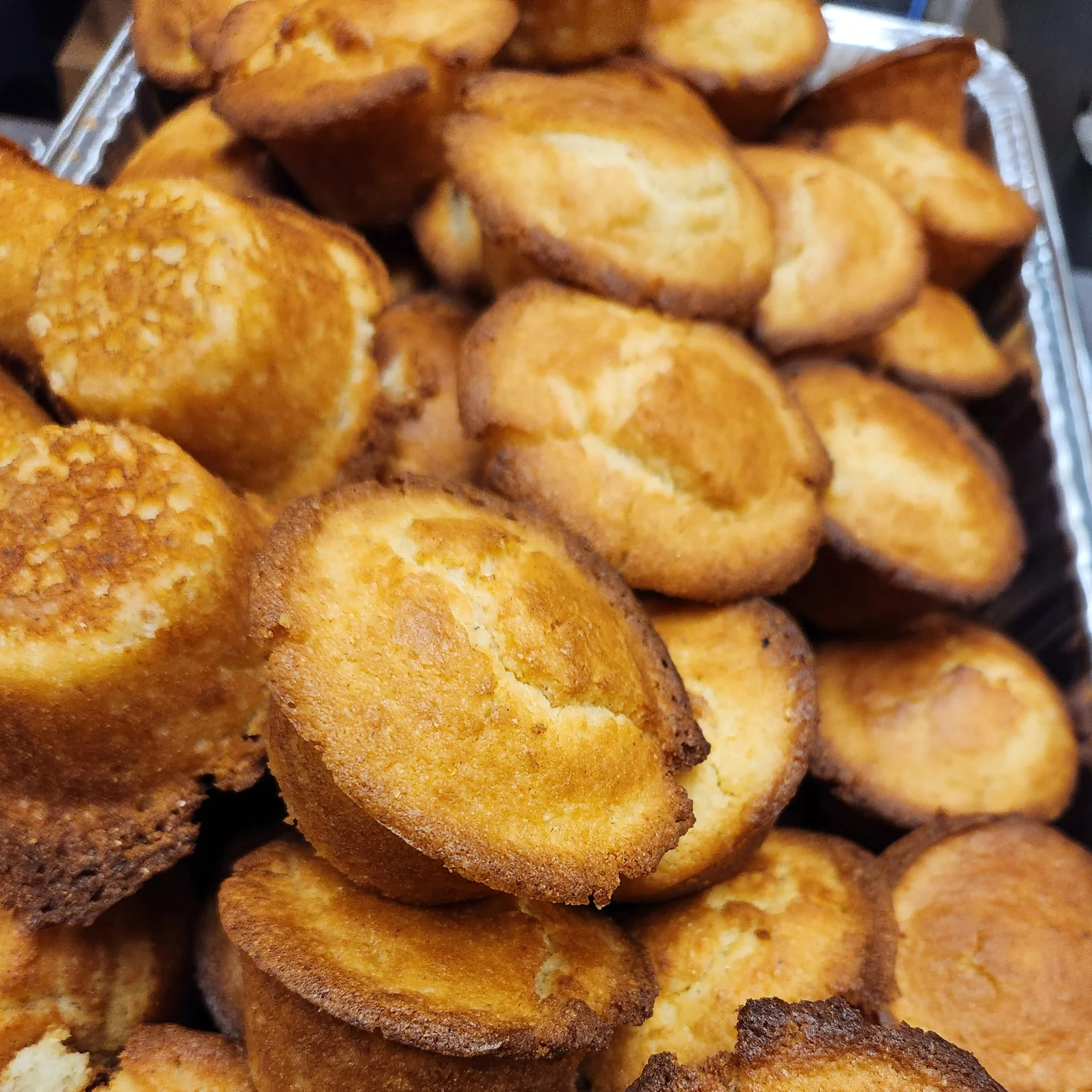 Freshly baked cornbread muffins in a warm display