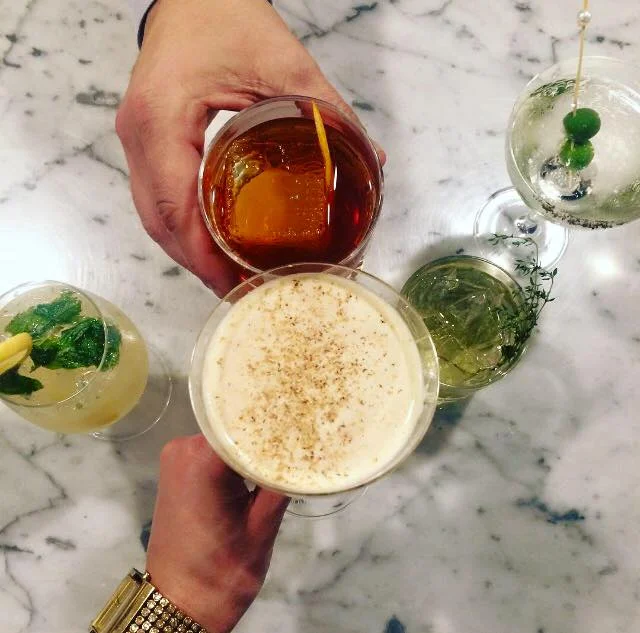 Colorful cocktails with floral garnish in a vibrant restaurant setting