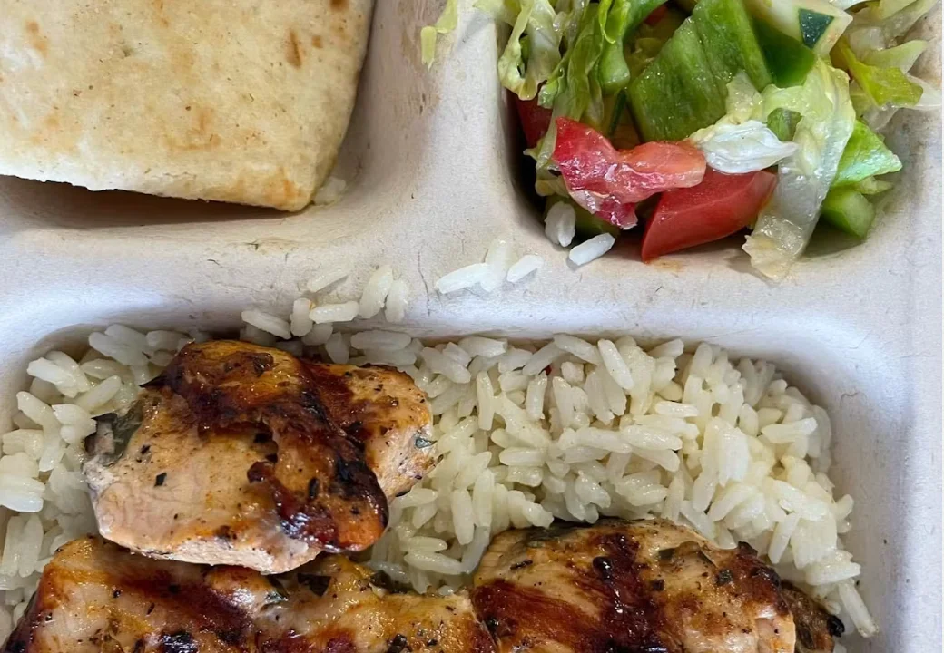 Grilled chicken with rice and salad in a Mediterranean platter