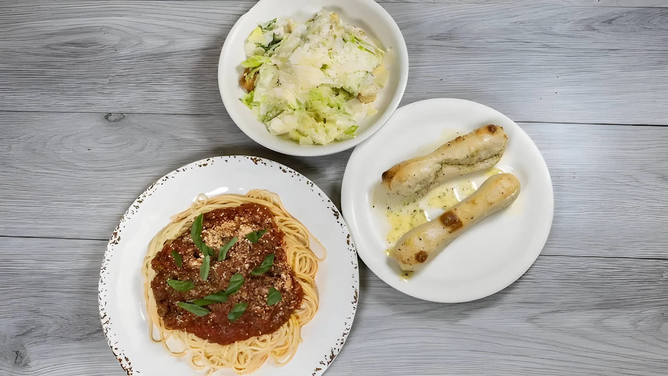 Classic spaghetti with marinara sauce and garlic bread on a rustic table
