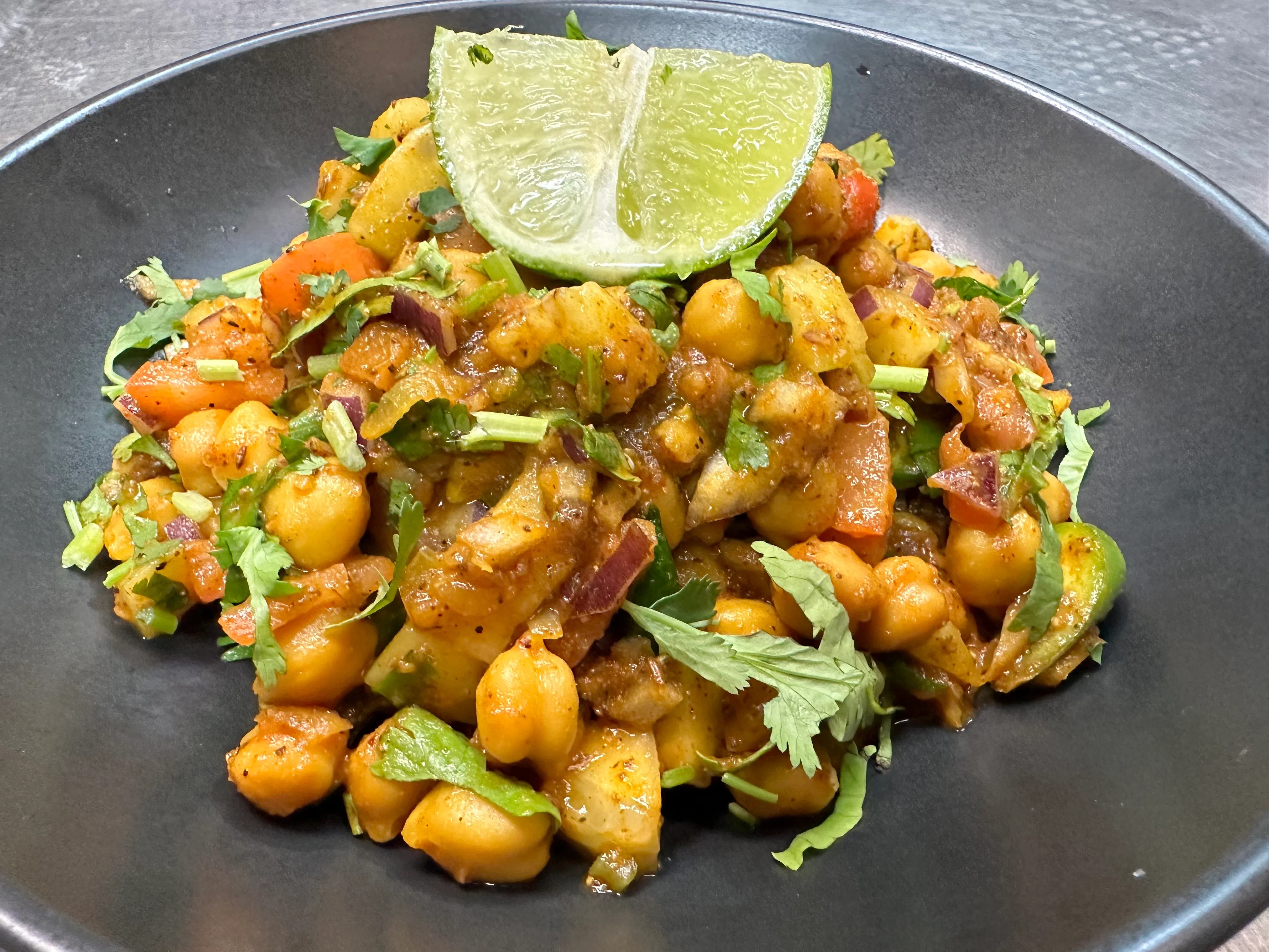 Spicy Indian chana chaat topped with fresh herbs and lime