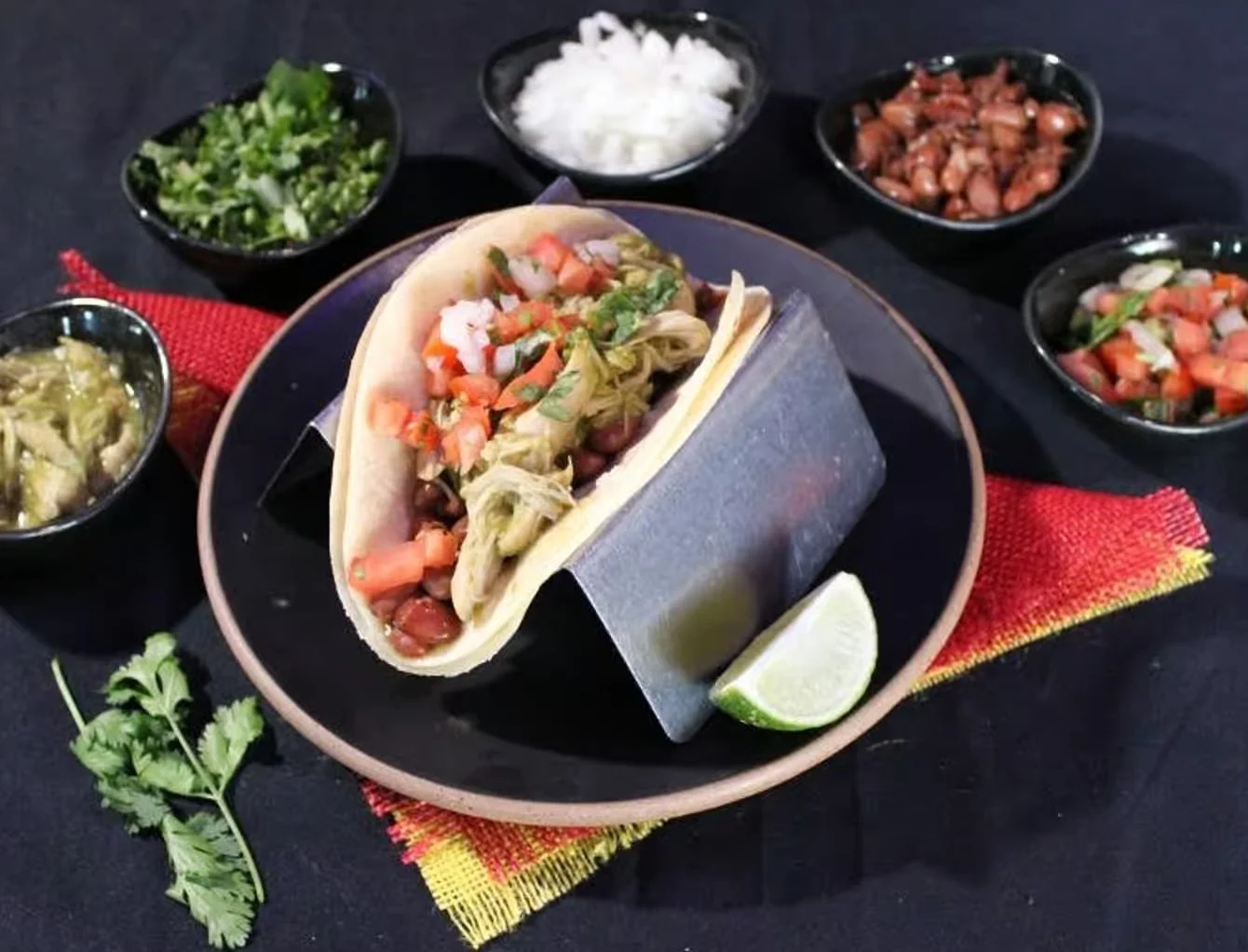 Taco with toppings on a black plate from Aztecon Broadway Mexican Restaurant