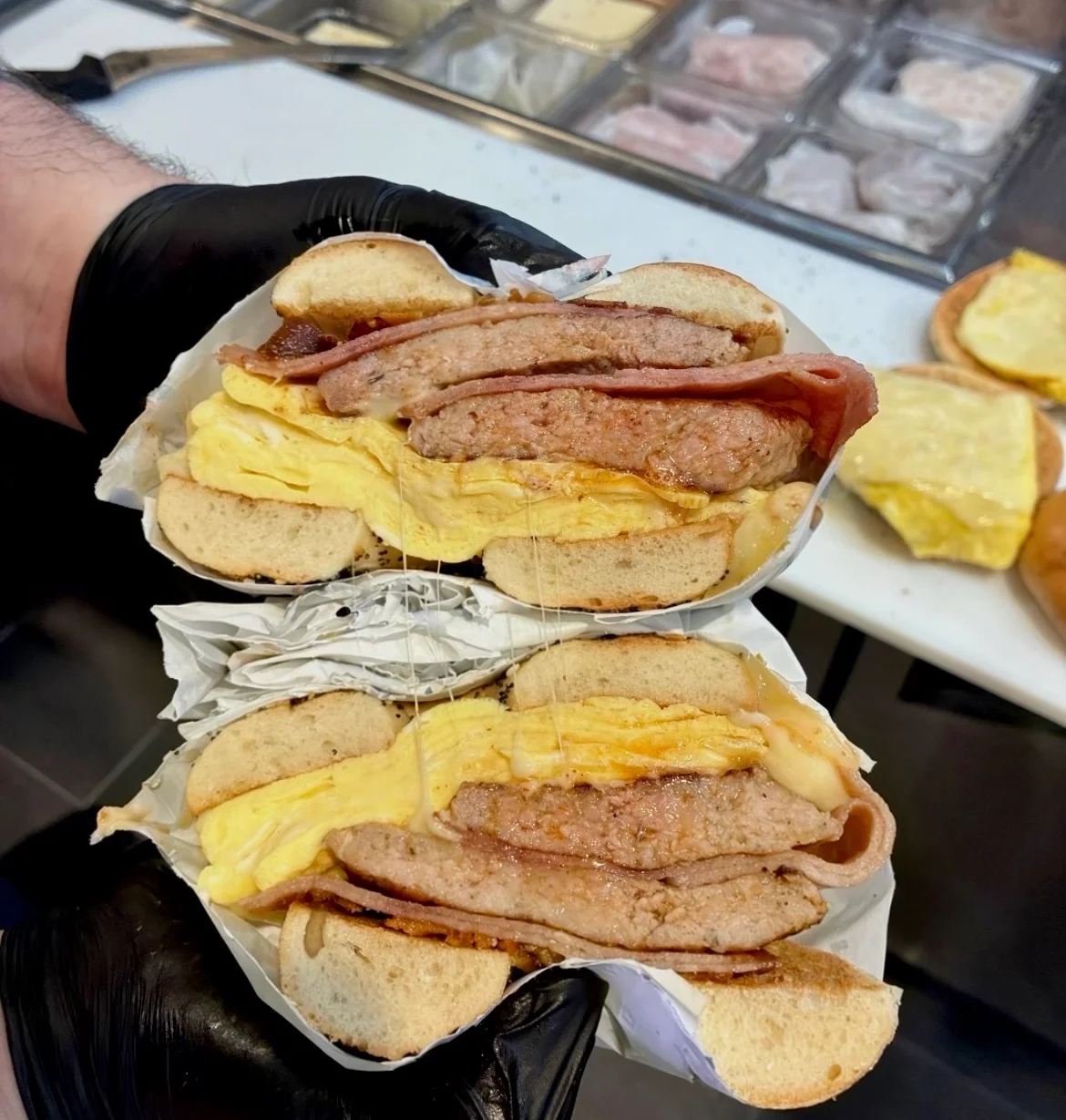 Hearty breakfast sandwich stacked with eggs and meats