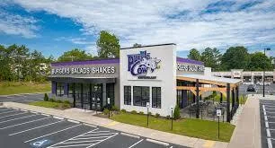 Exterior view of The Purple Cow restaurant with neon signage