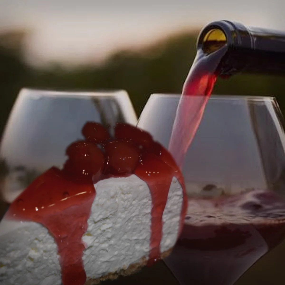 Slice of cherry cheesecake with red wine pouring in the background