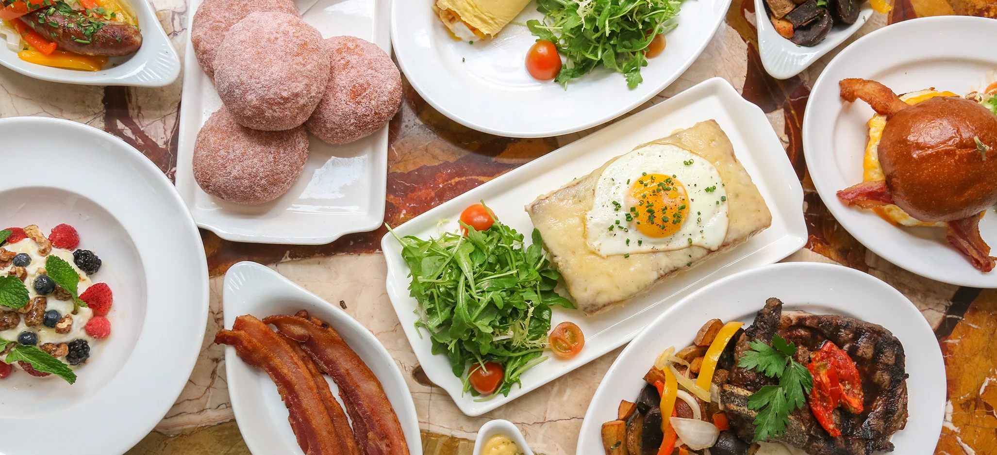 A variety of delicious dishes including salads, donuts, and a burger.