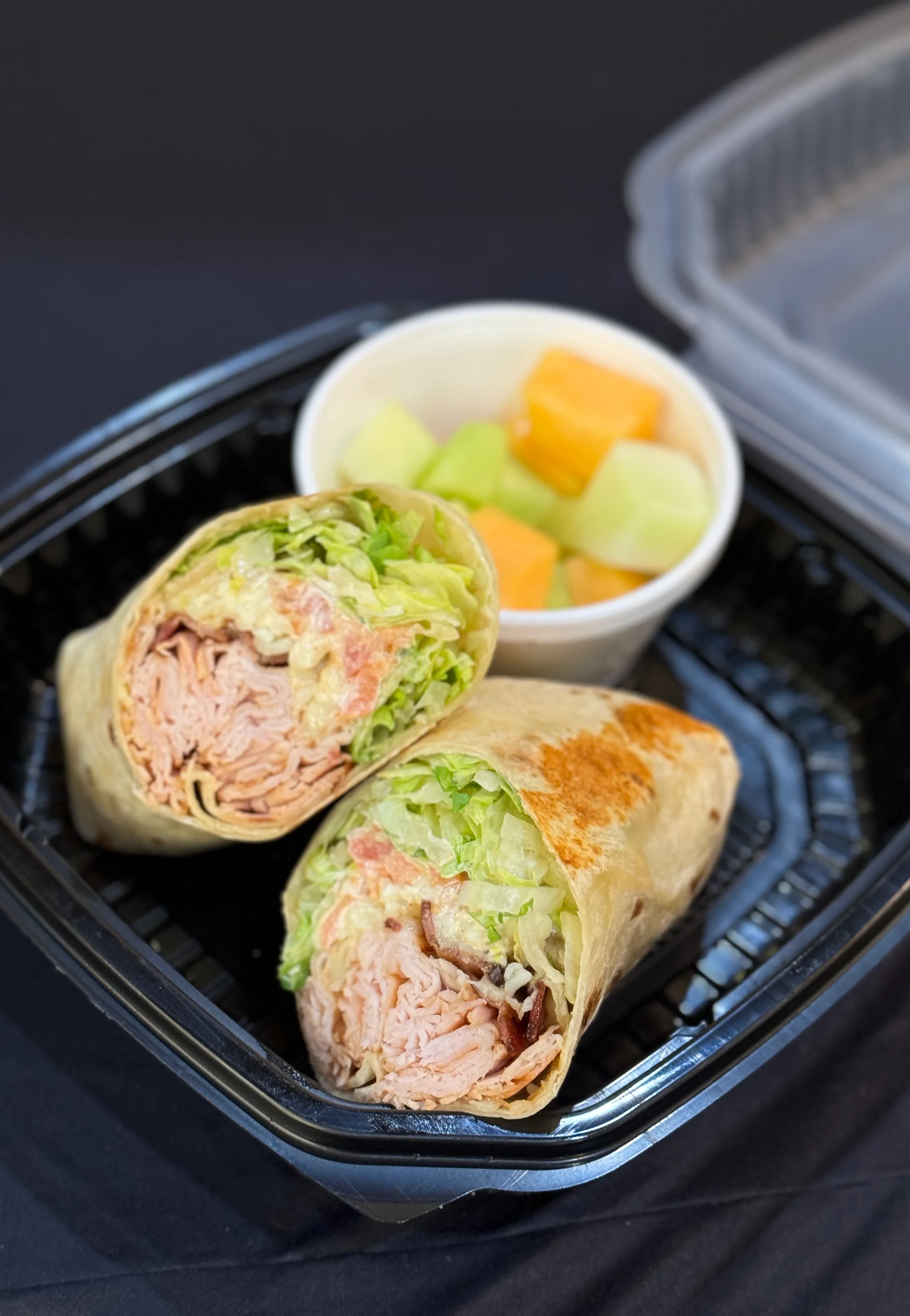 Turkey wrap with lettuce and fresh fruit on the side