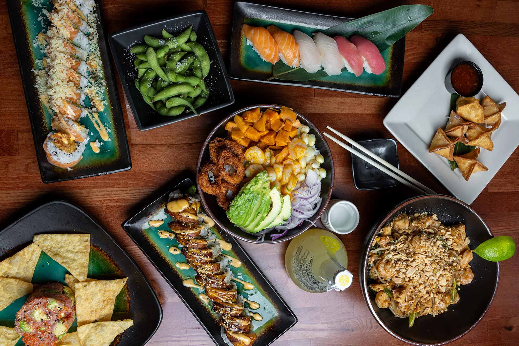 Assorted sushi and Asian fusion dishes on a wooden table