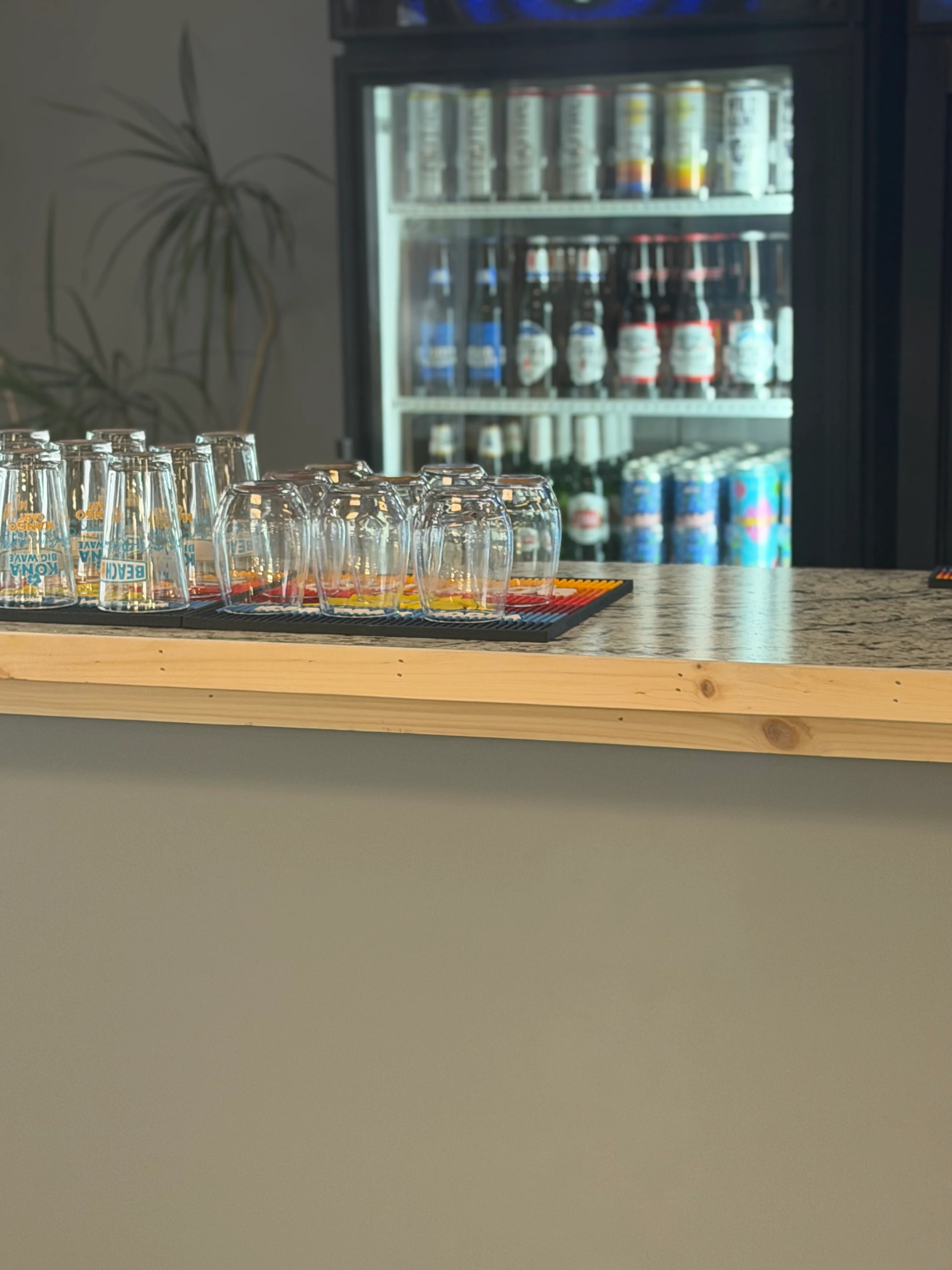 Modern bar counter with glassware and a beverage fridge
