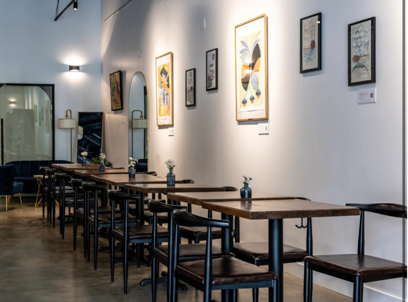 Interior of a modern restaurant with tables and wall art.