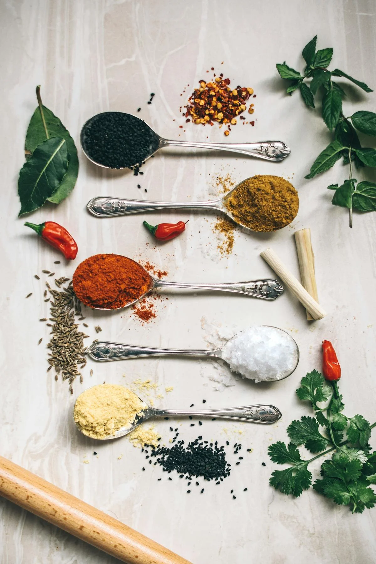 Assorted spices for Indian cuisine on a marble surface