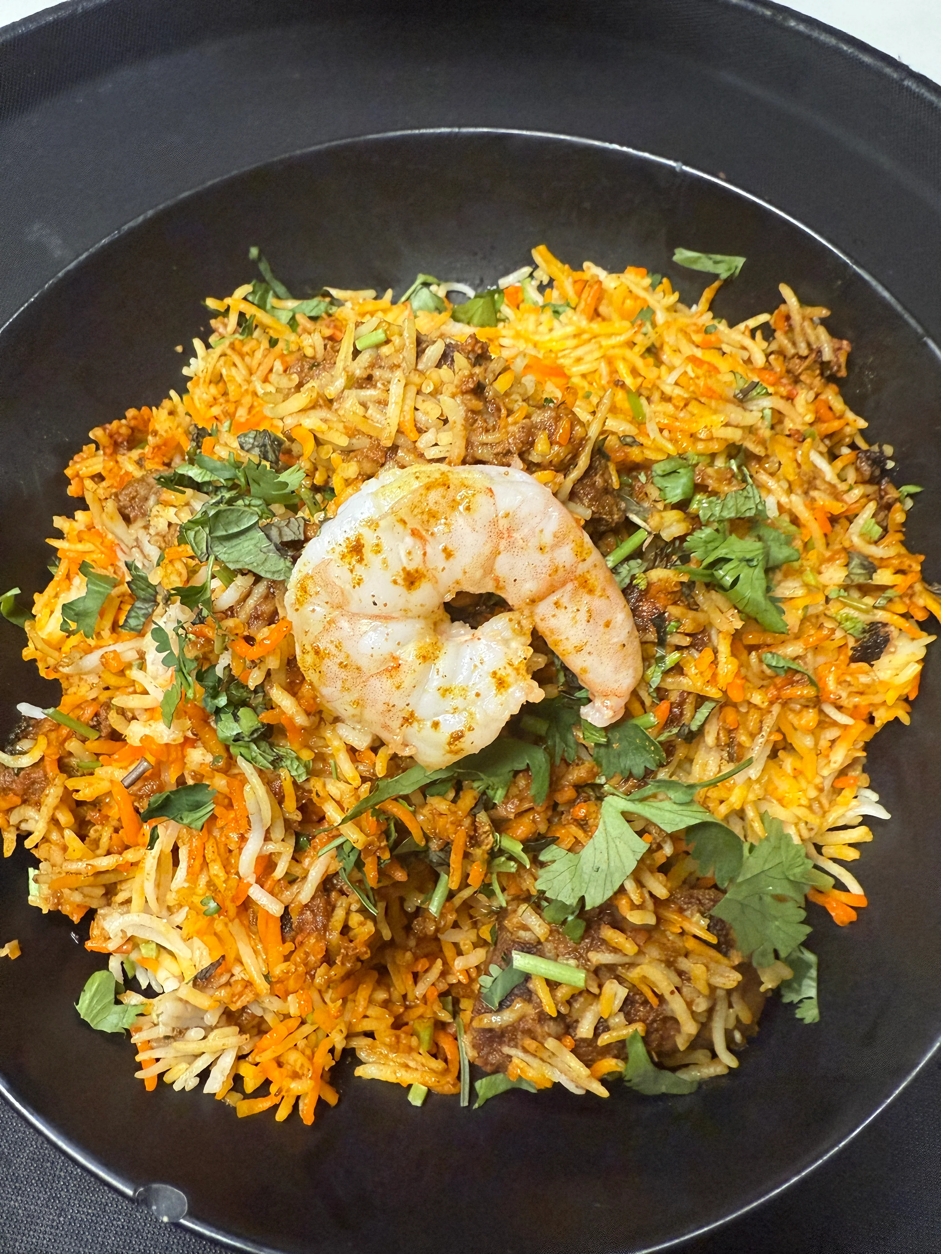 Flavorful shrimp biryani garnished with fresh herbs