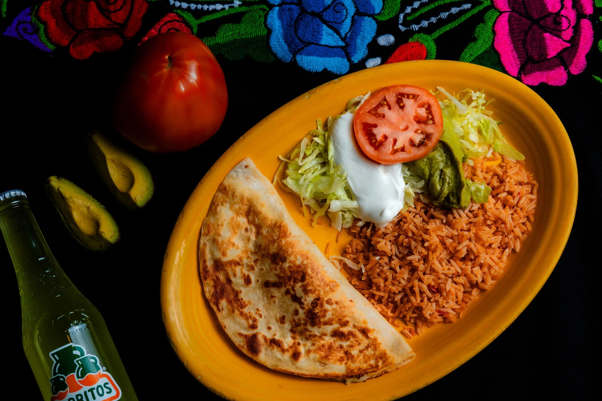 Mexican plate with quesadilla, rice, and fresh toppings