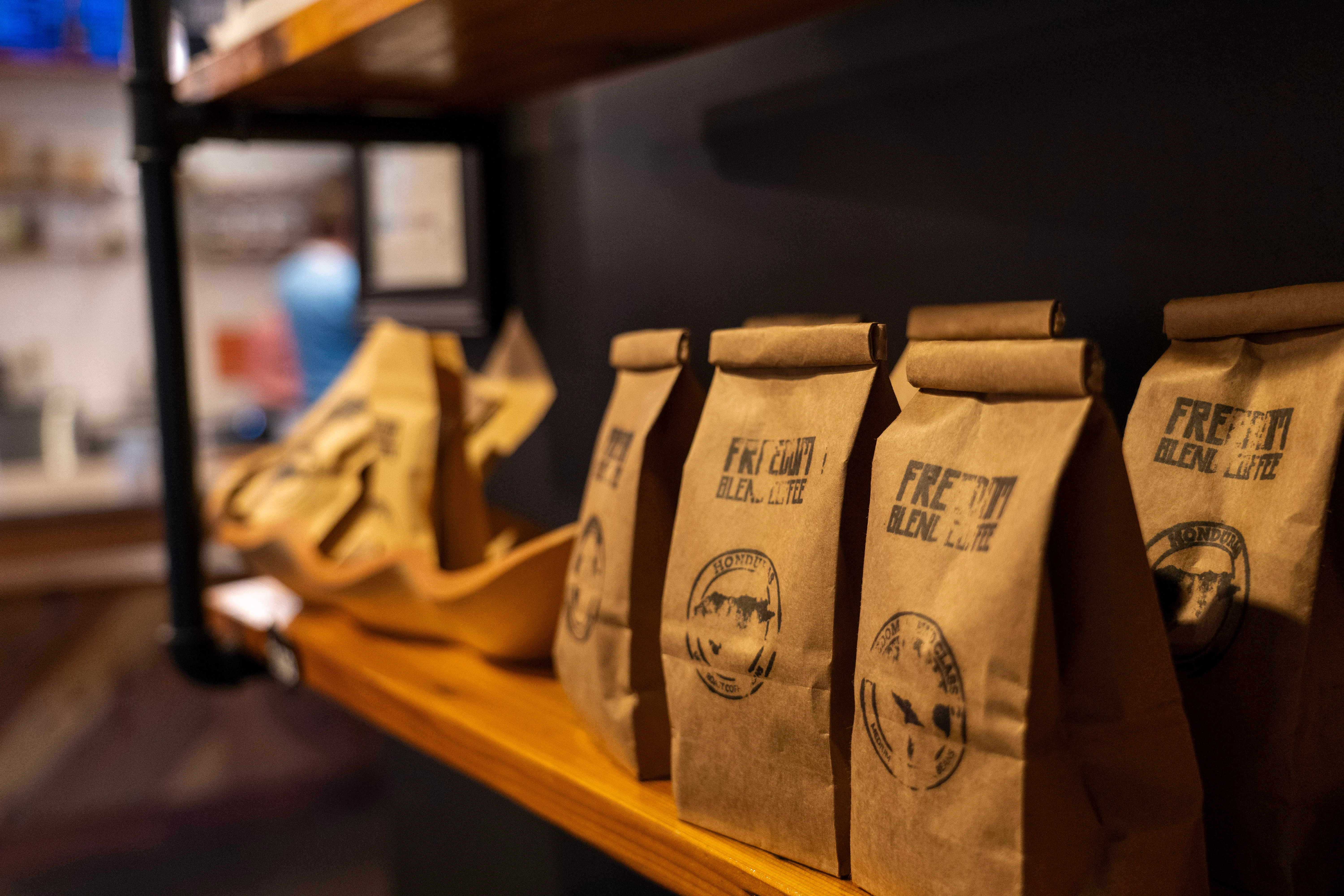 Coffee bags on a wooden shelf in a cozy café