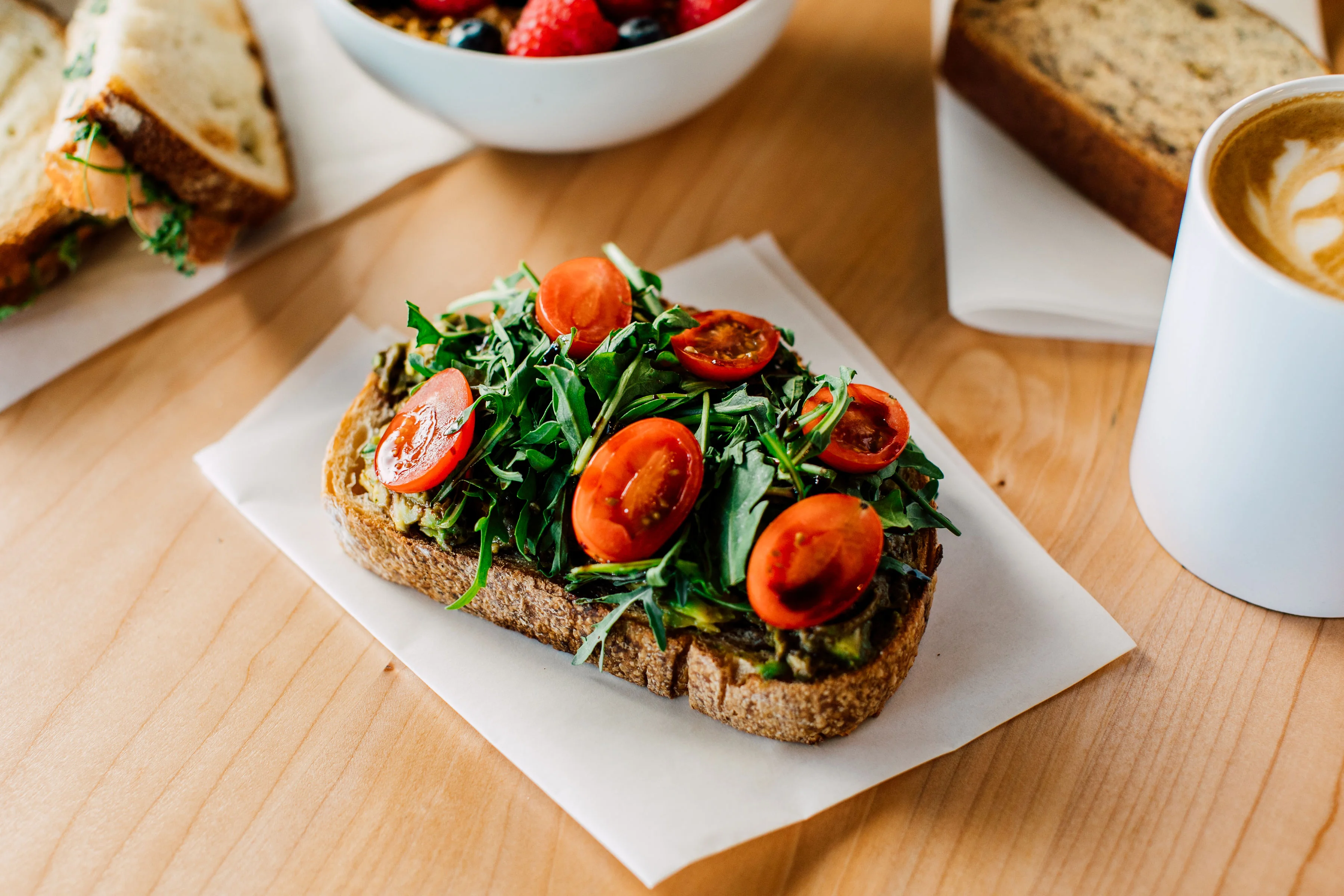 Avocado toast topped with arugula and cherry tomatoes